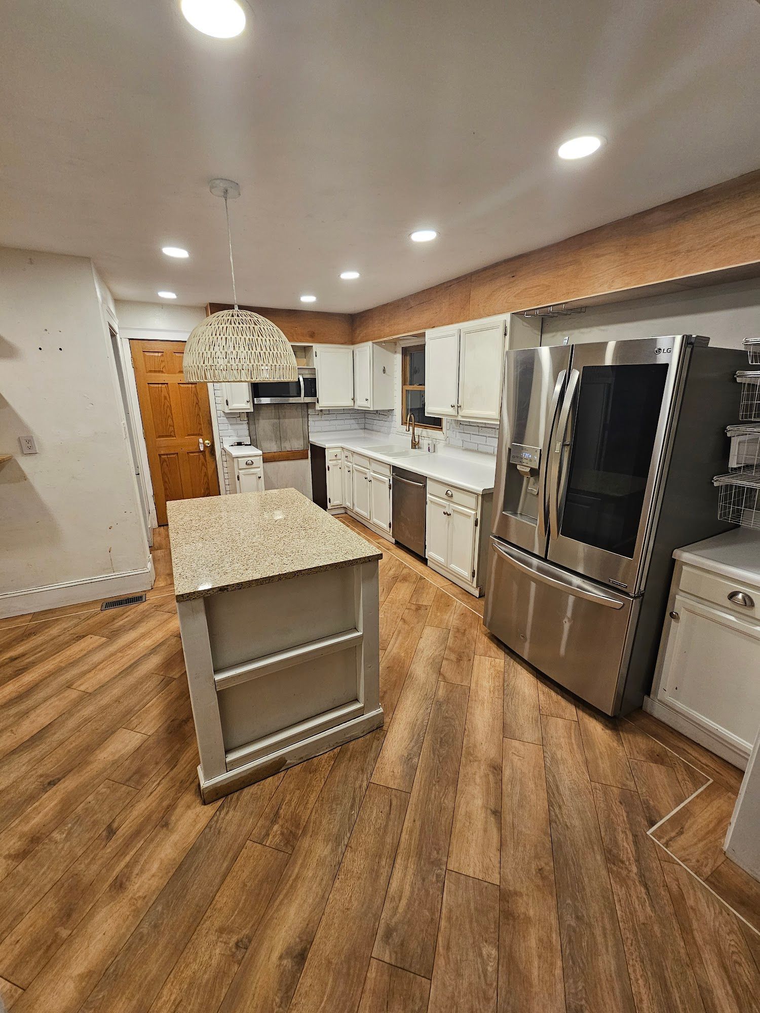 A kitchen with stainless steel appliances , granite counter tops , and a large island.