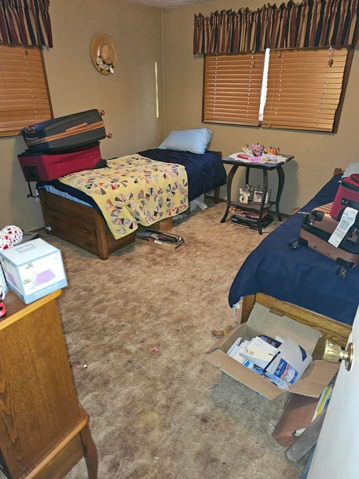 A bedroom with two beds , a dresser , and a window.