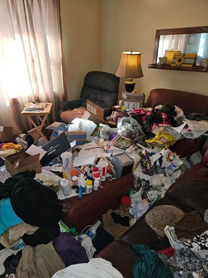 A living room filled with lots of junk and a couch.