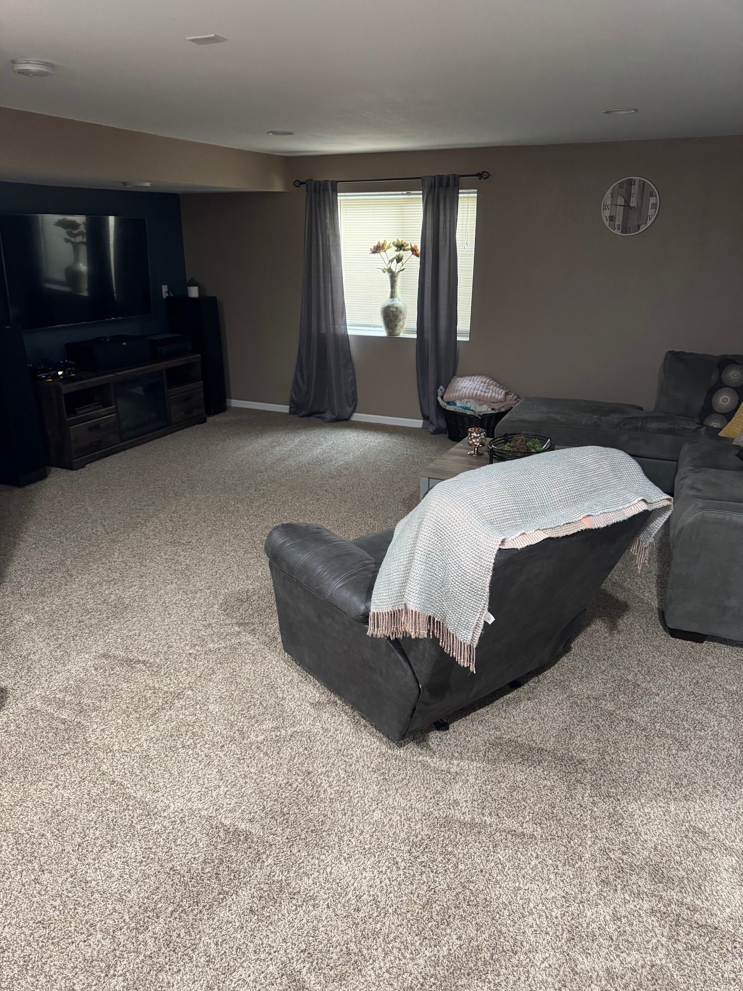 A living room with a couch , chair , and television.