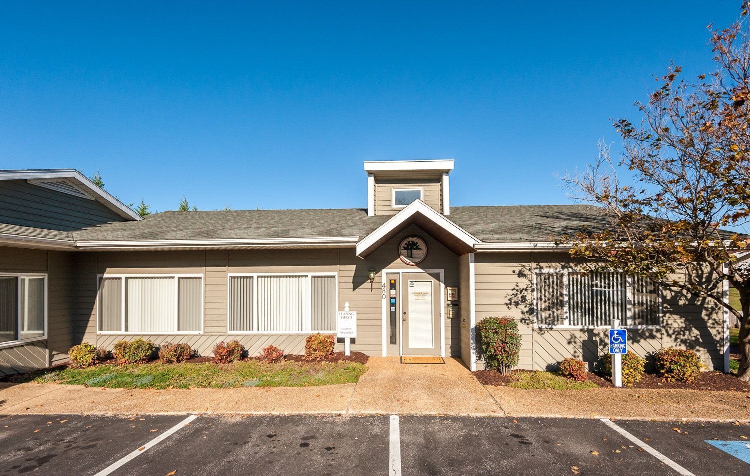 A large clubhouse with a parking lot in front of it.
