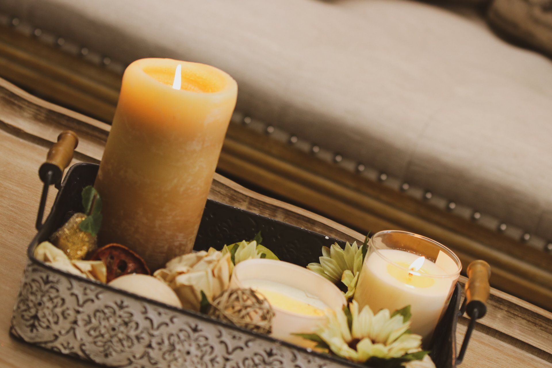 A metal tray filled with candles and flowers on a wooden table at Results Skincare Studio in Fort Myers