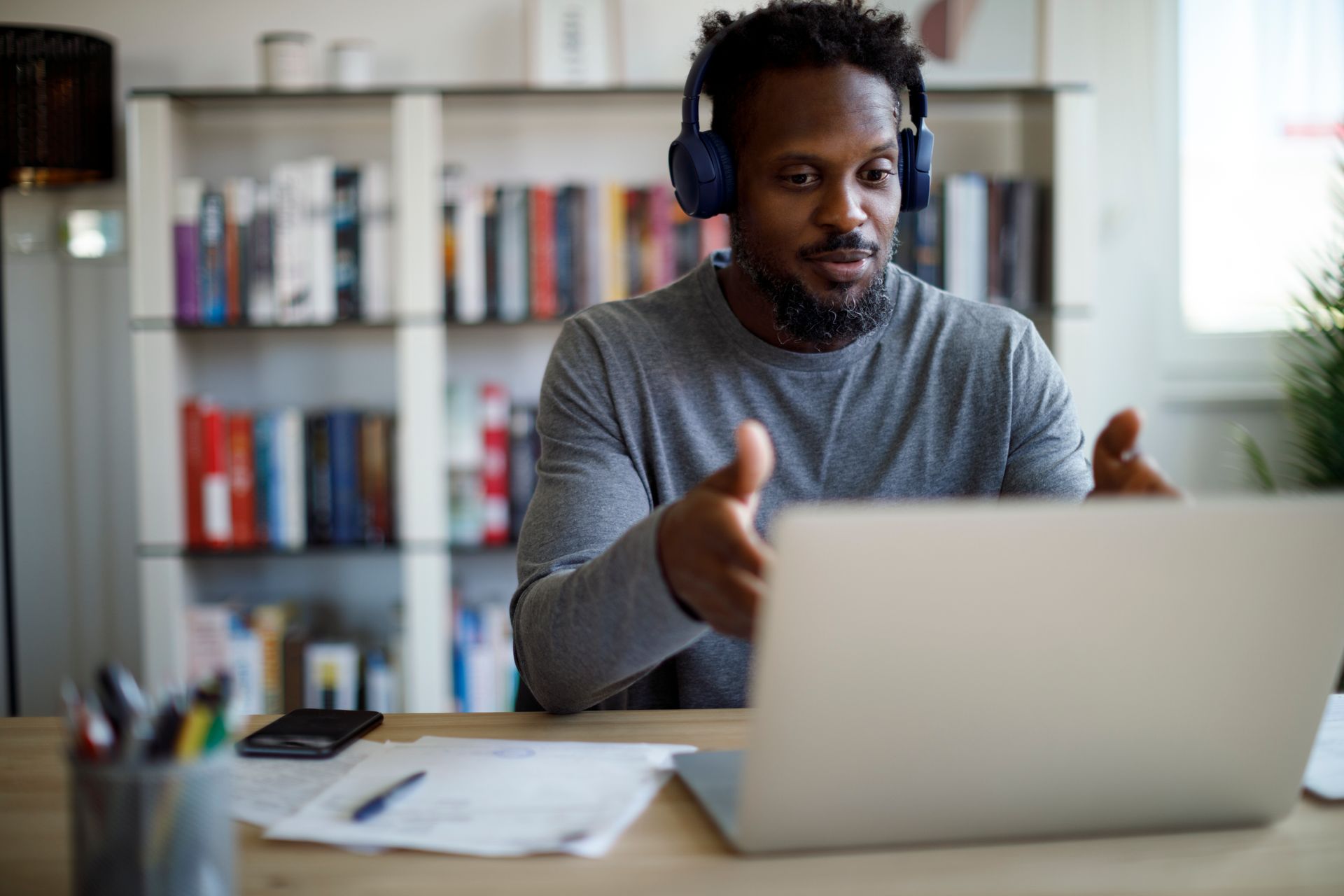 a man wearing headphones is sitting in front of a laptop computer