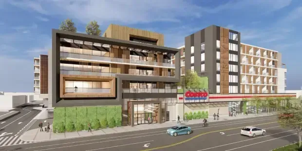 Modern mixed-use building complex with storefronts, balconies, and cars on a city street