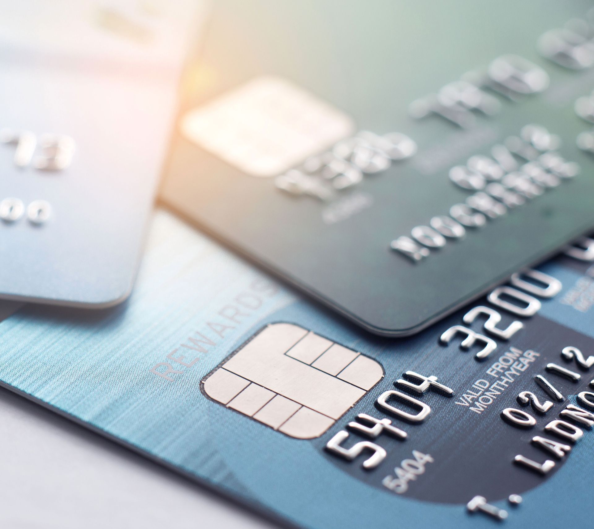 Close-up of overlapping blue and gray credit cards on a white surface