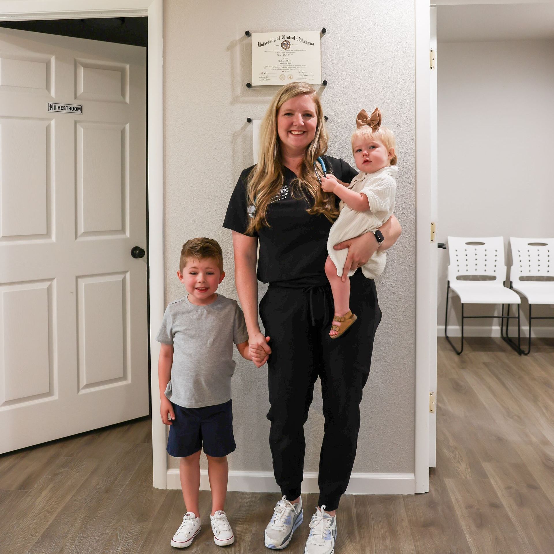 Pediatrician standing in an office hallway with two children