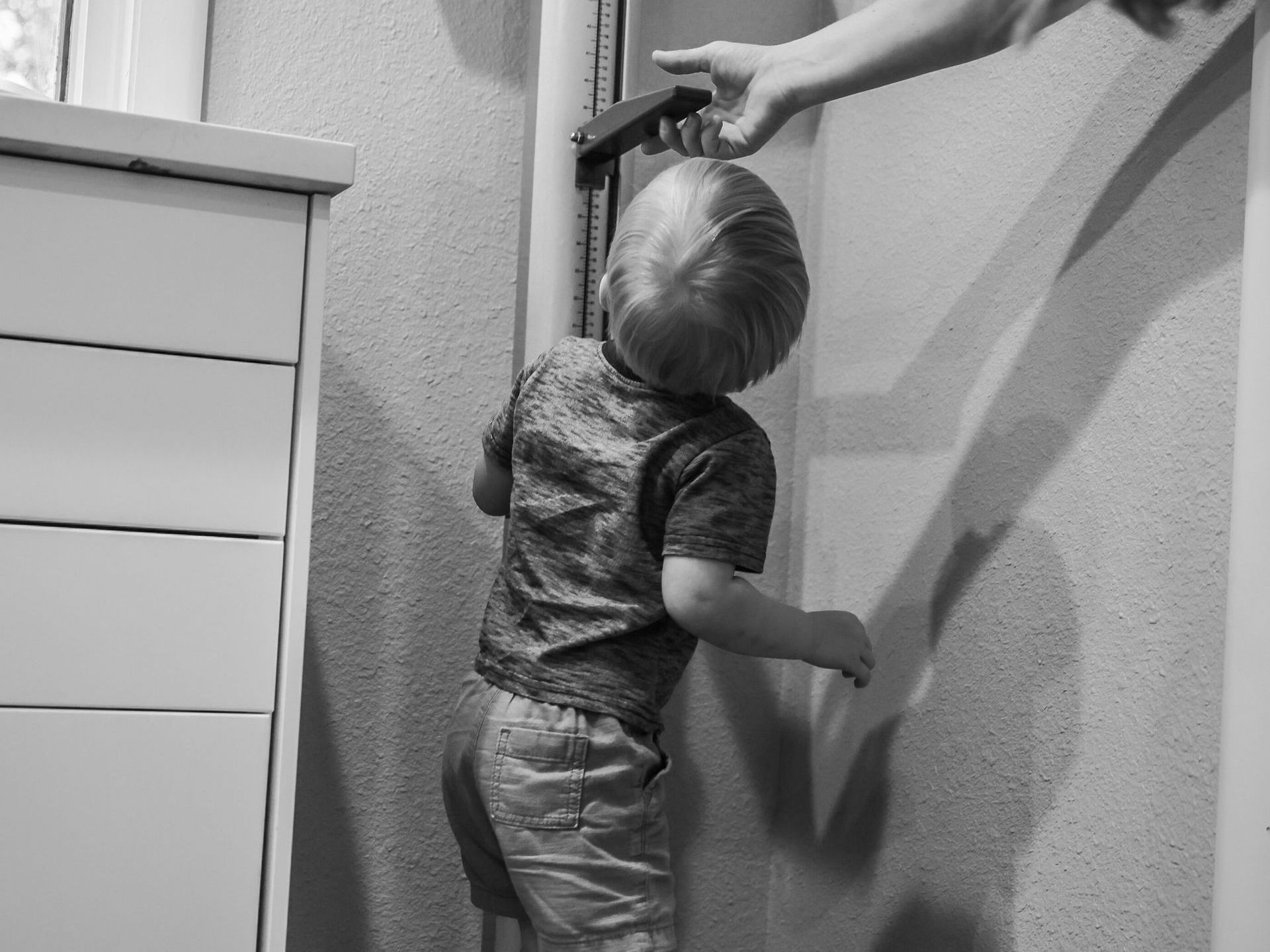 Child looking up as he's being measured for height