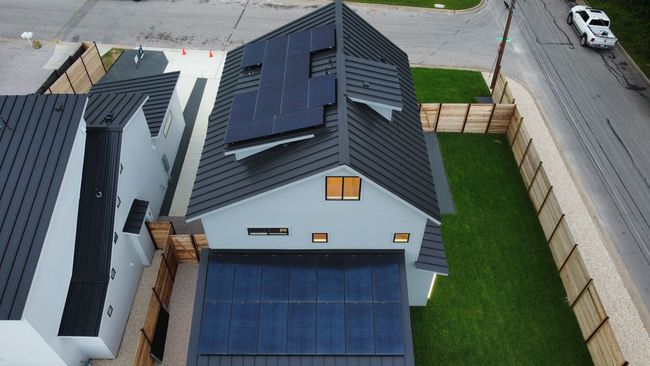 An aerial view of a house with solar panels on the roof