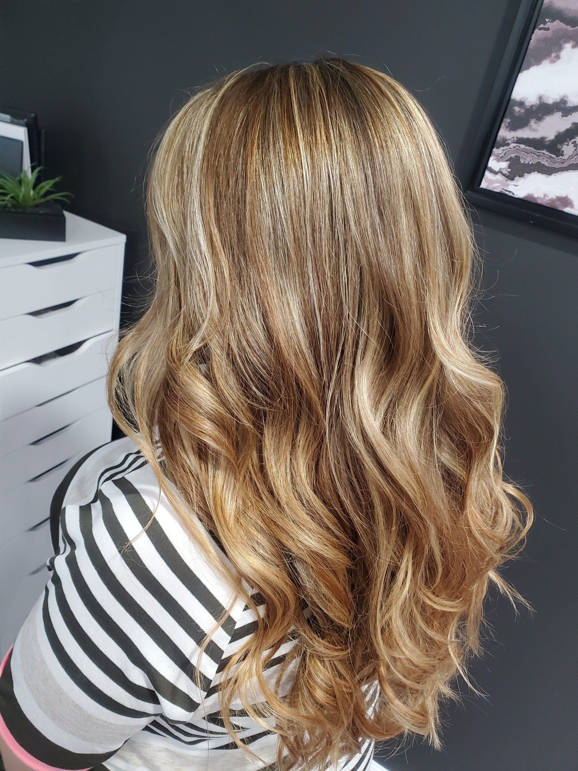 Woman with wavy, highlighted blonde and brown hair.