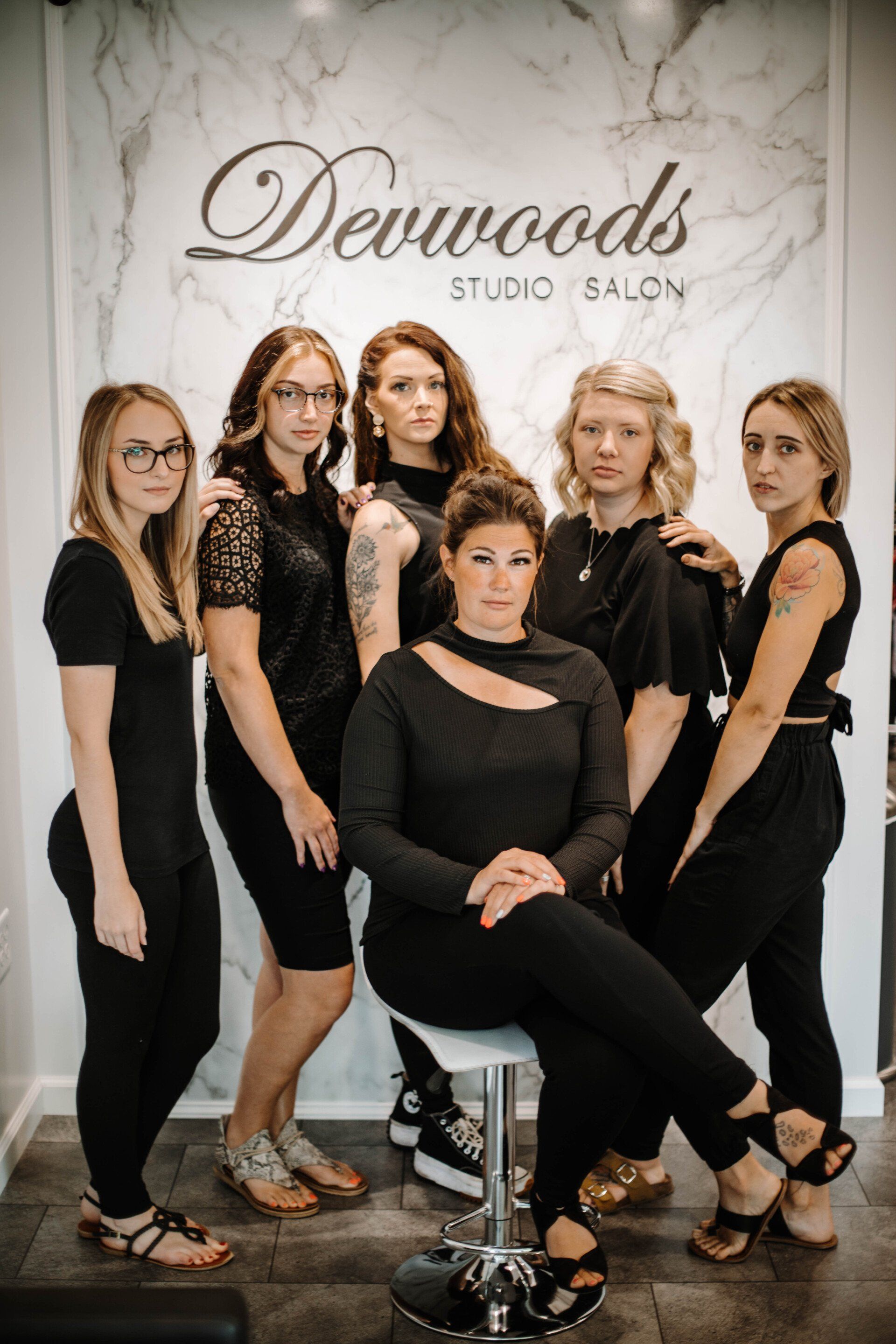 Group of stylists in black outfits at Devwoods Studio Salon.