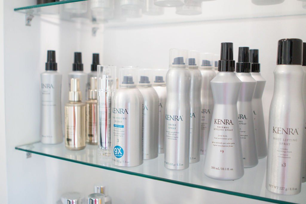 Shelves stocked with silver Kenra hair products in a salon.