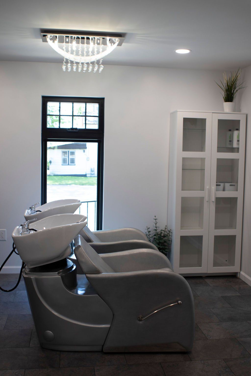 Hair salon with three shampoo stations, cabinet, and window.