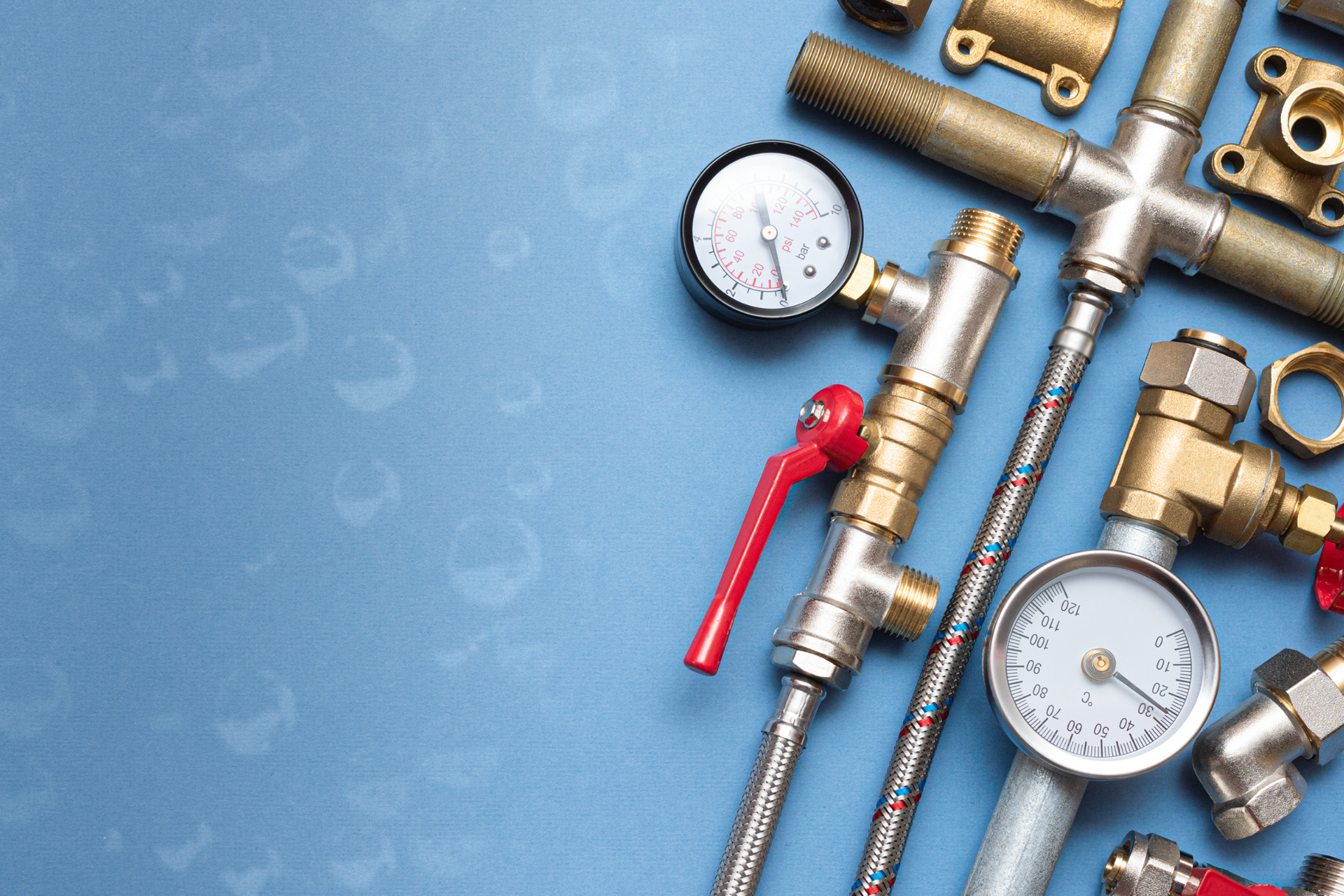 A bunch of plumbing pipes and gauges on a blue background.
