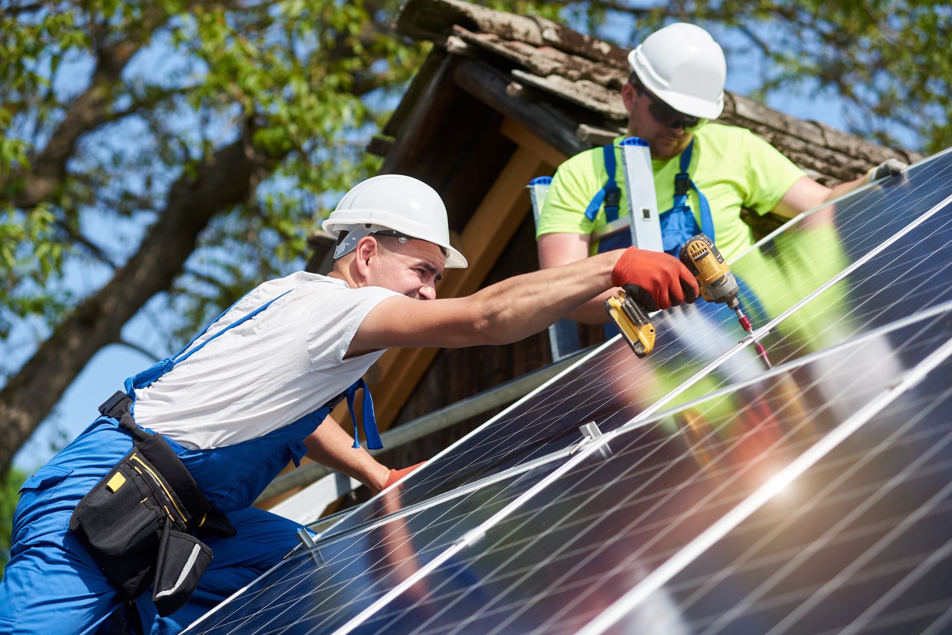 Contractors in protective gear installing solar panels. Contractors in protective gear installing solar panels.