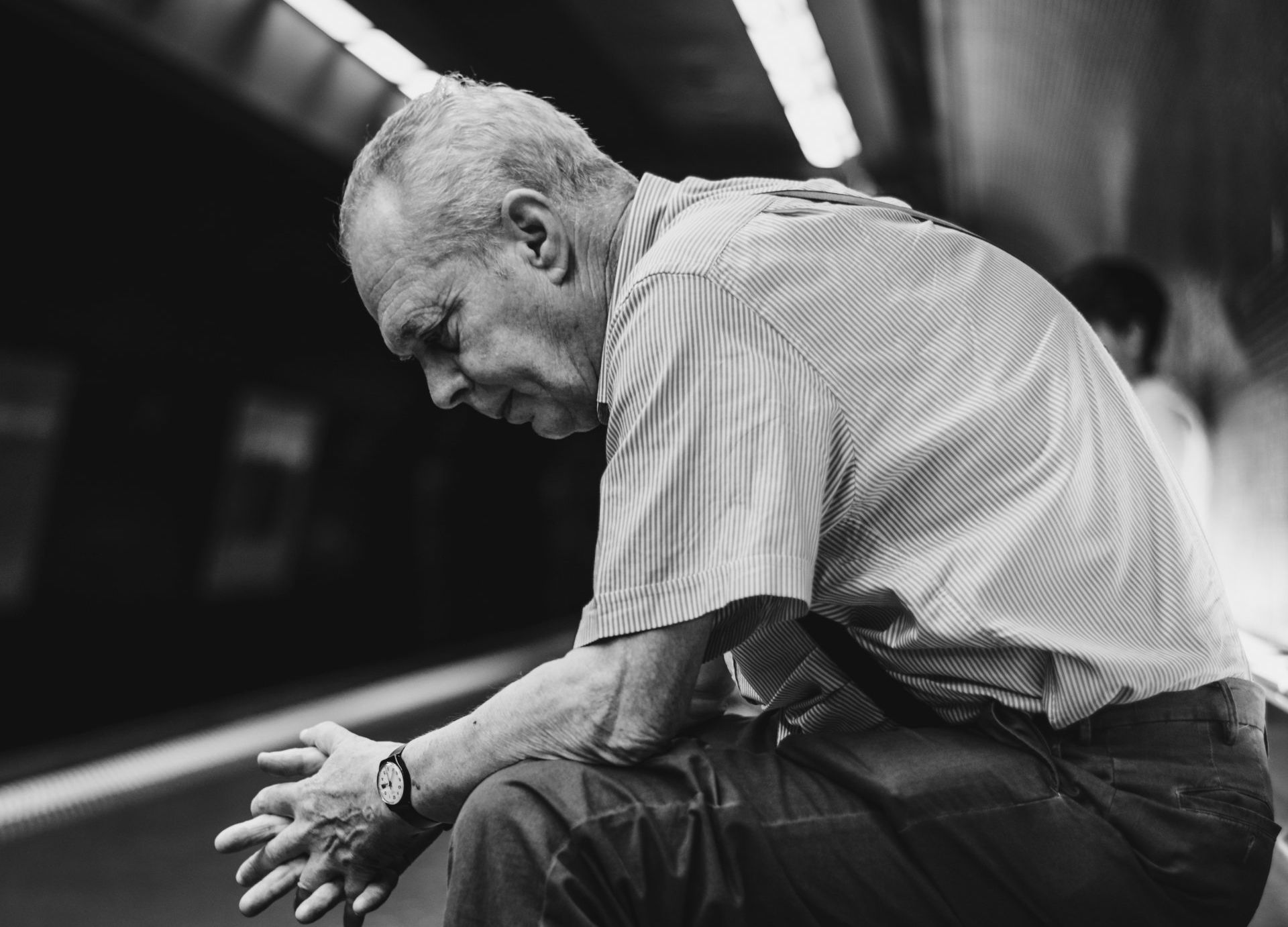 Uma foto em preto e branco de um homem idoso sentado no chão.