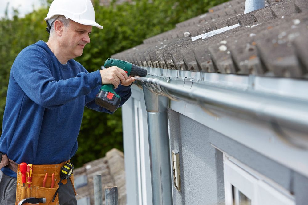 Man Repairing Gutter System — Professional Roofer in Alice River, QLD