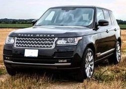 Black Range Rover SUV parked in a field, front view.