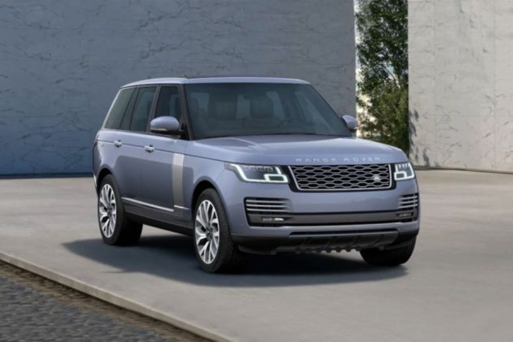 A light blue Range Rover SUV parked in front of a modern building.