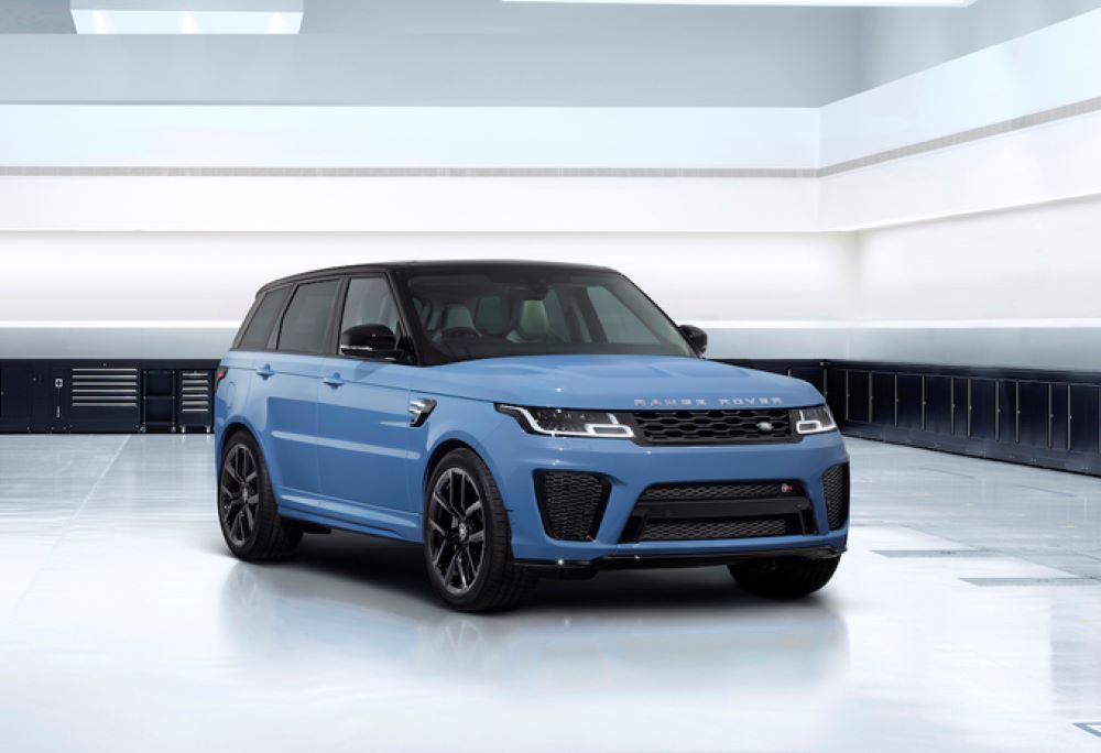 A light blue Range Rover Sport SUV with a black roof parked in a white studio.