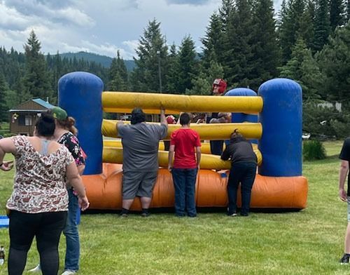 A group of people are standing in front of an inflatable boxing ring.