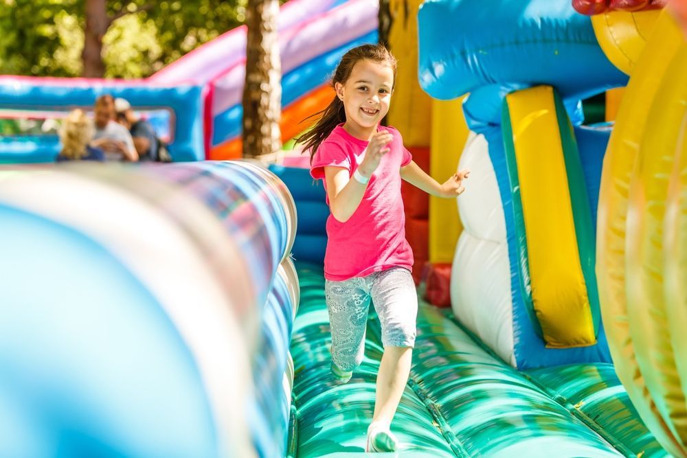 A little girl is running through a bouncy house.