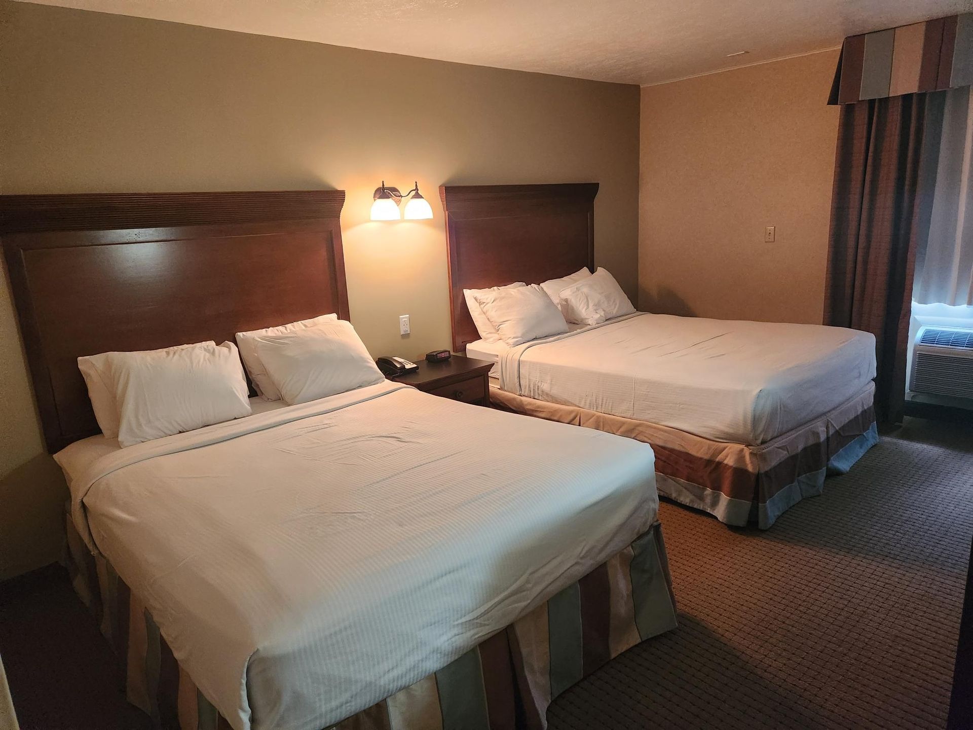 A hotel room with two beds and a window