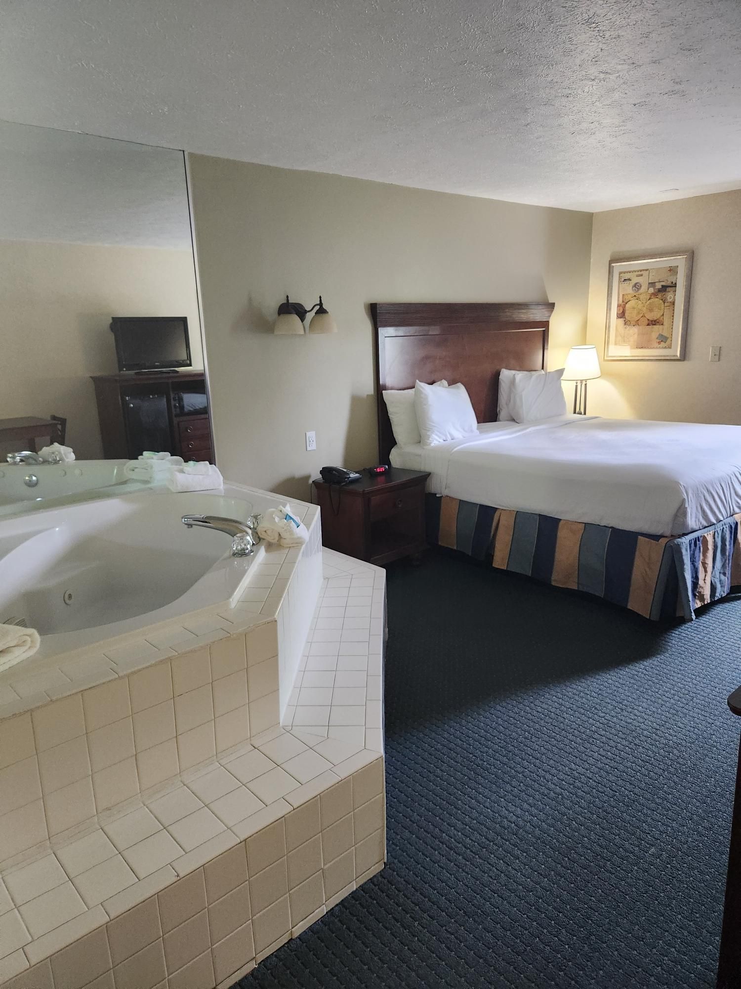 A hotel room with a bed and a jacuzzi tub