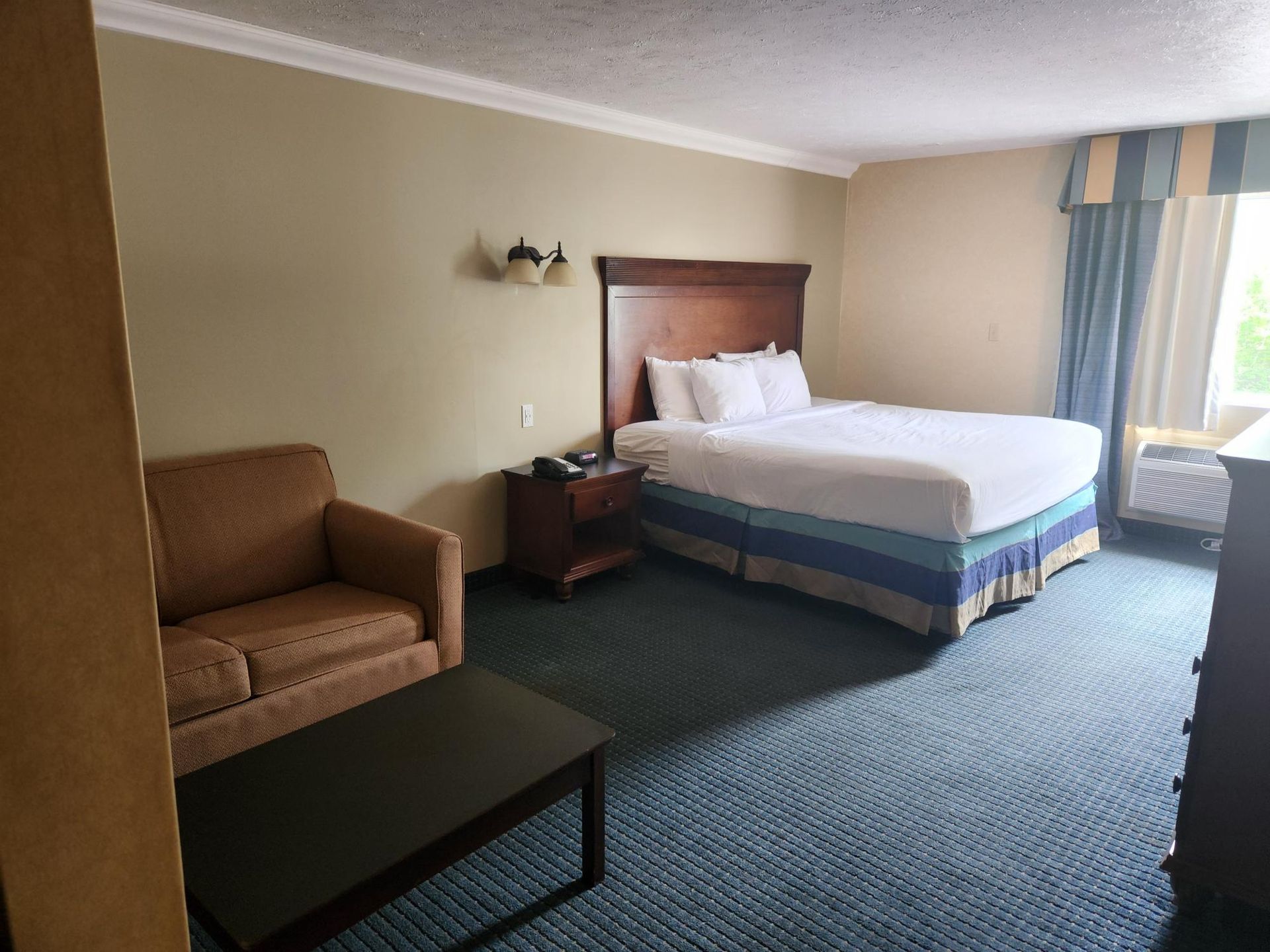 A hotel room with a king size bed and a couch.