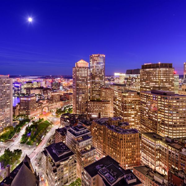 An aerial view of a city at night with lots of buildings lit up.