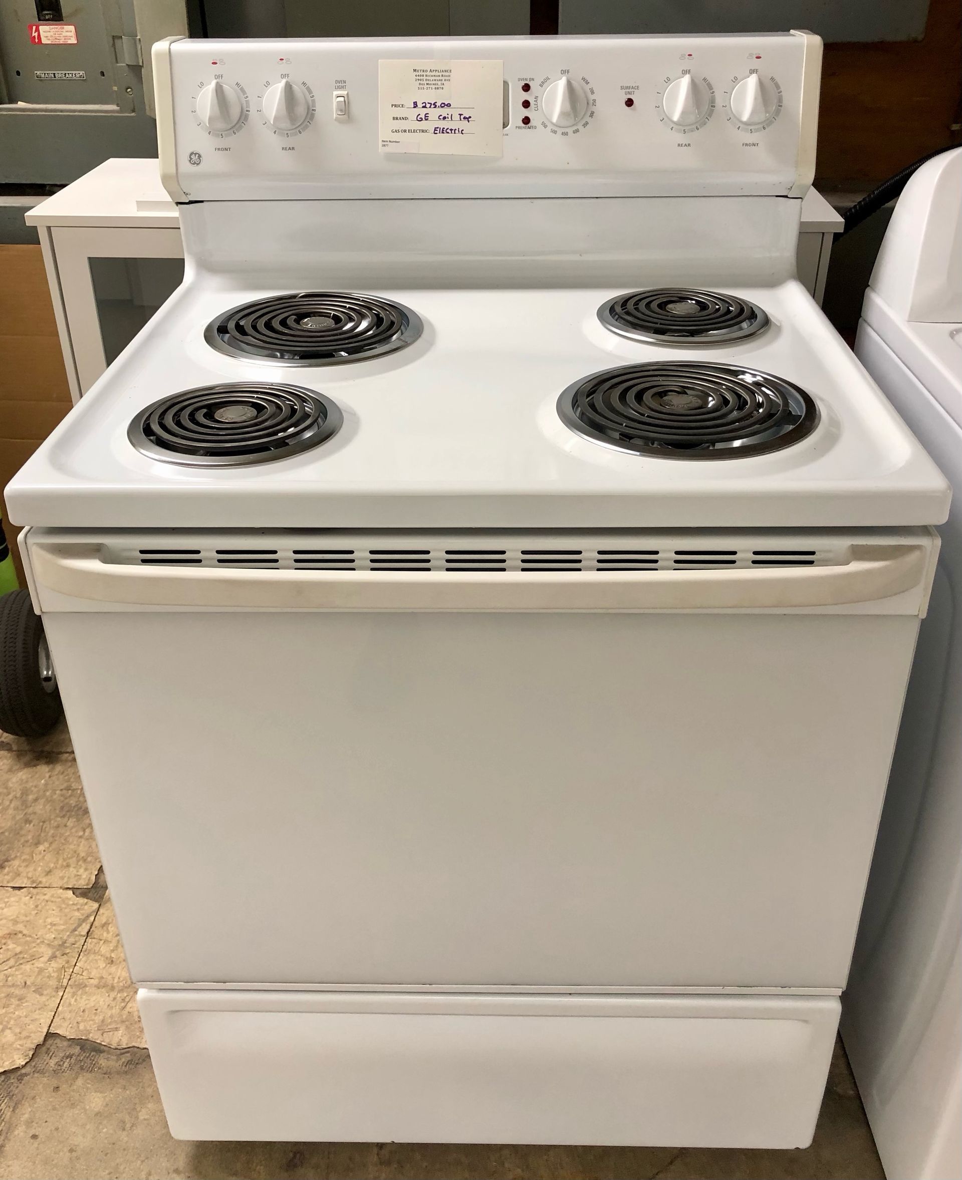 White electric stove with four coil burners and oven door, shown front view in a kitchen-like setting