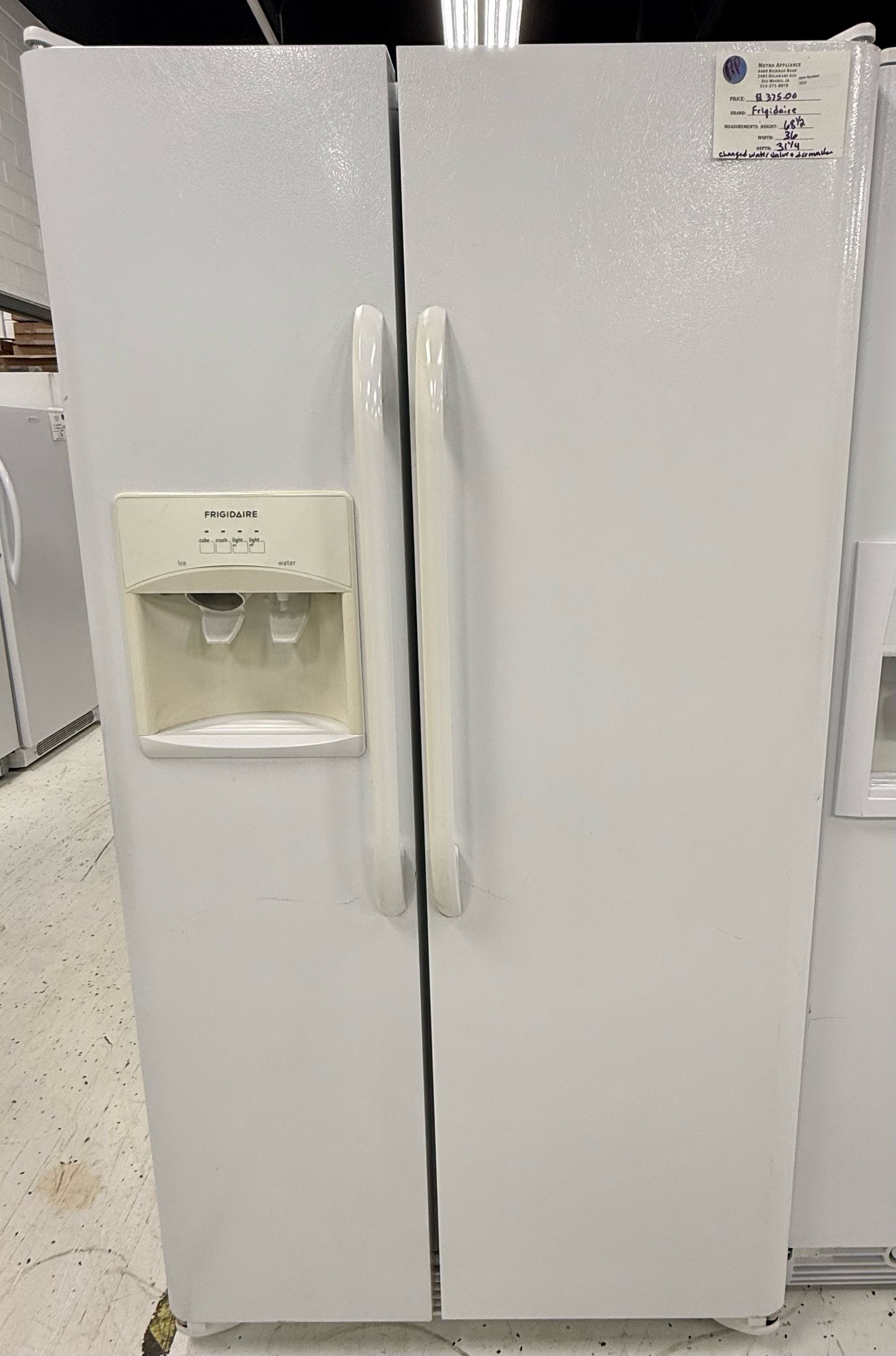 White side-by-side refrigerator with water and ice dispenser, shown in a store aisle.