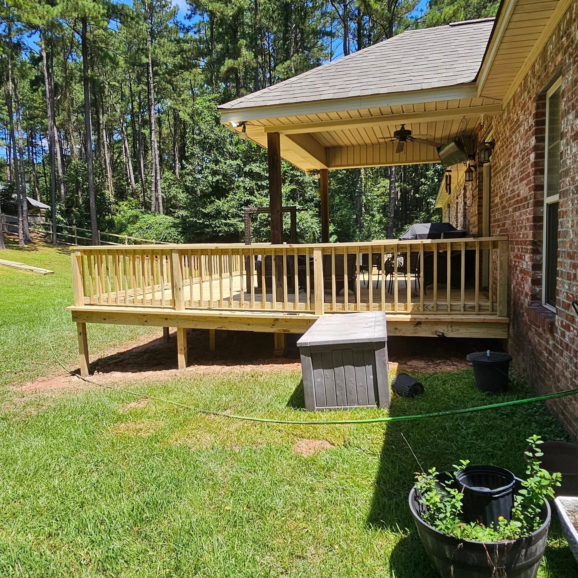 A brick house with a wooden deck in the backyard.