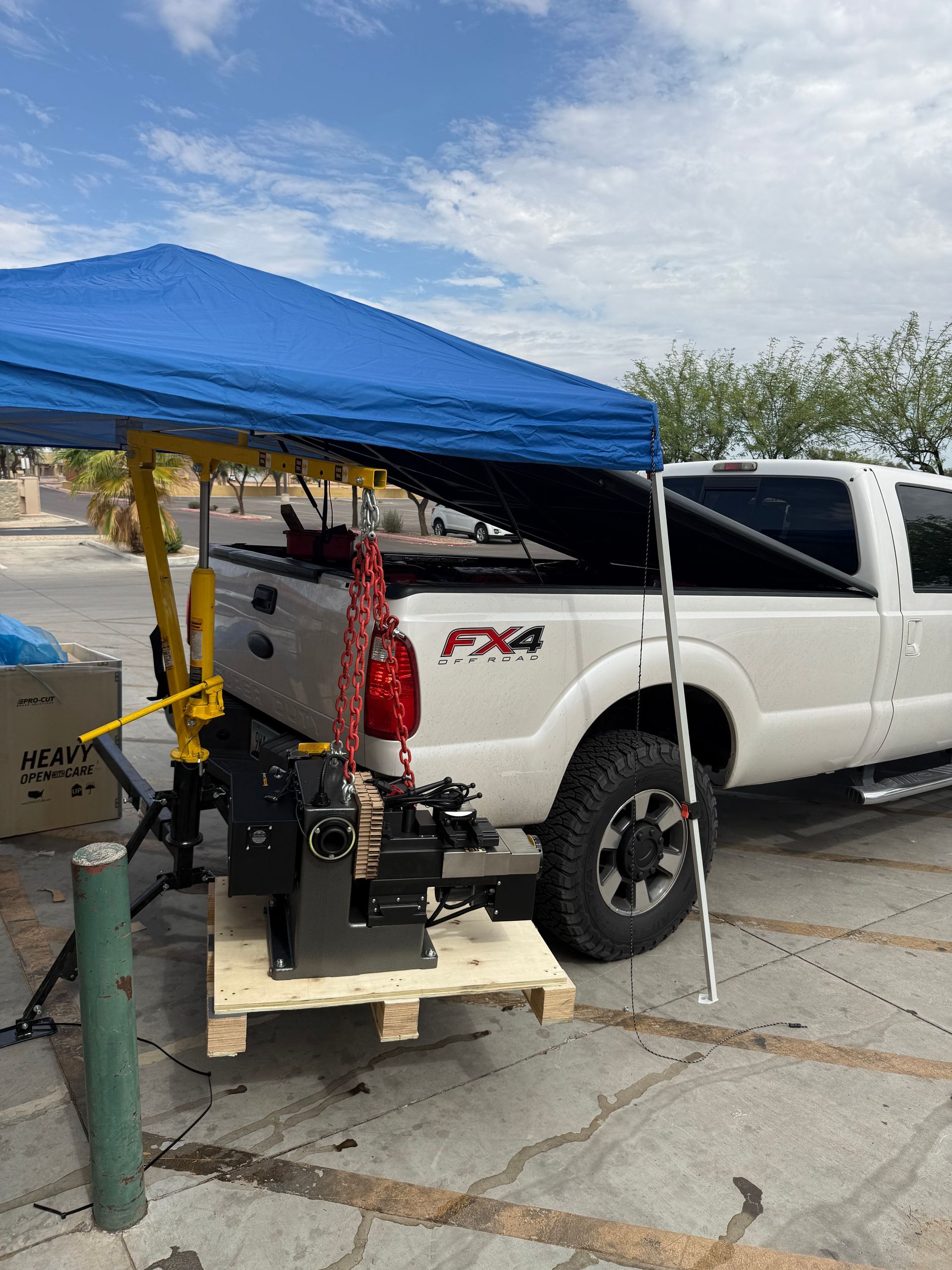 Red telescopic forklift with raised forks on gravel in a sunny desert lot