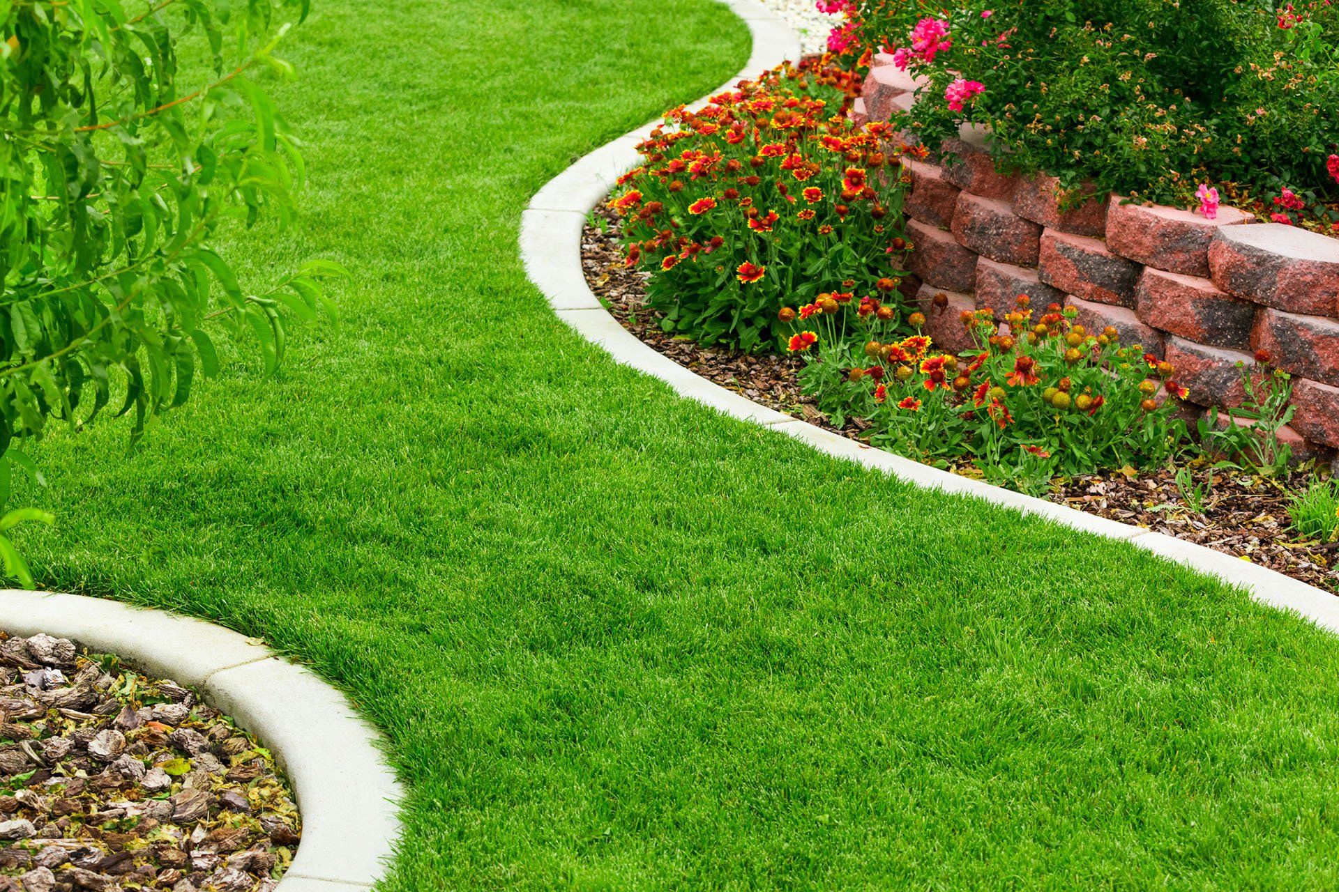 Curving Curbs Set Around Flower Bed and Loose Stone