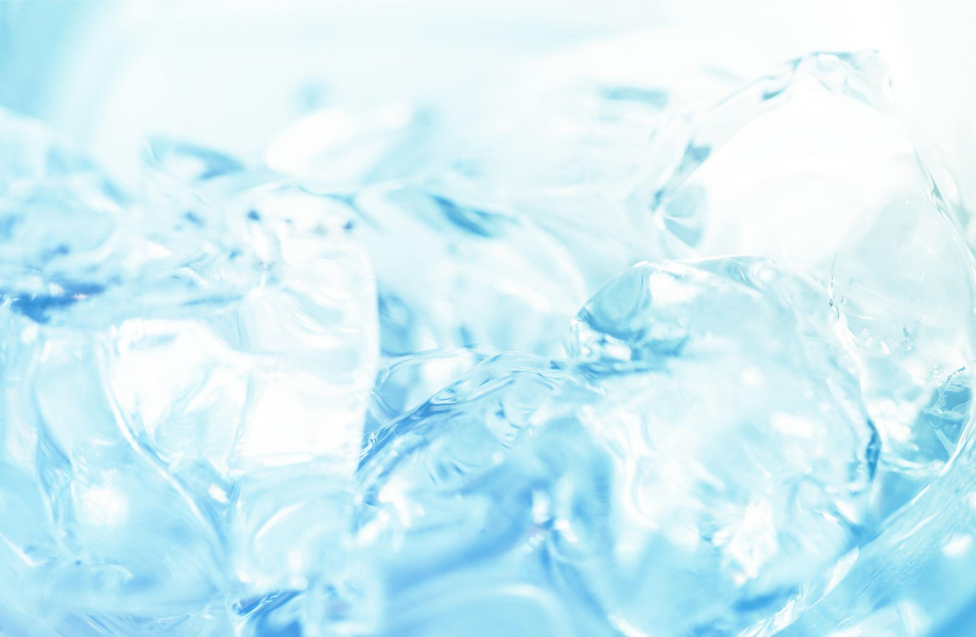 Gros plan sur des glaçons ; de couleur bleutée, transparents et réfléchissants.