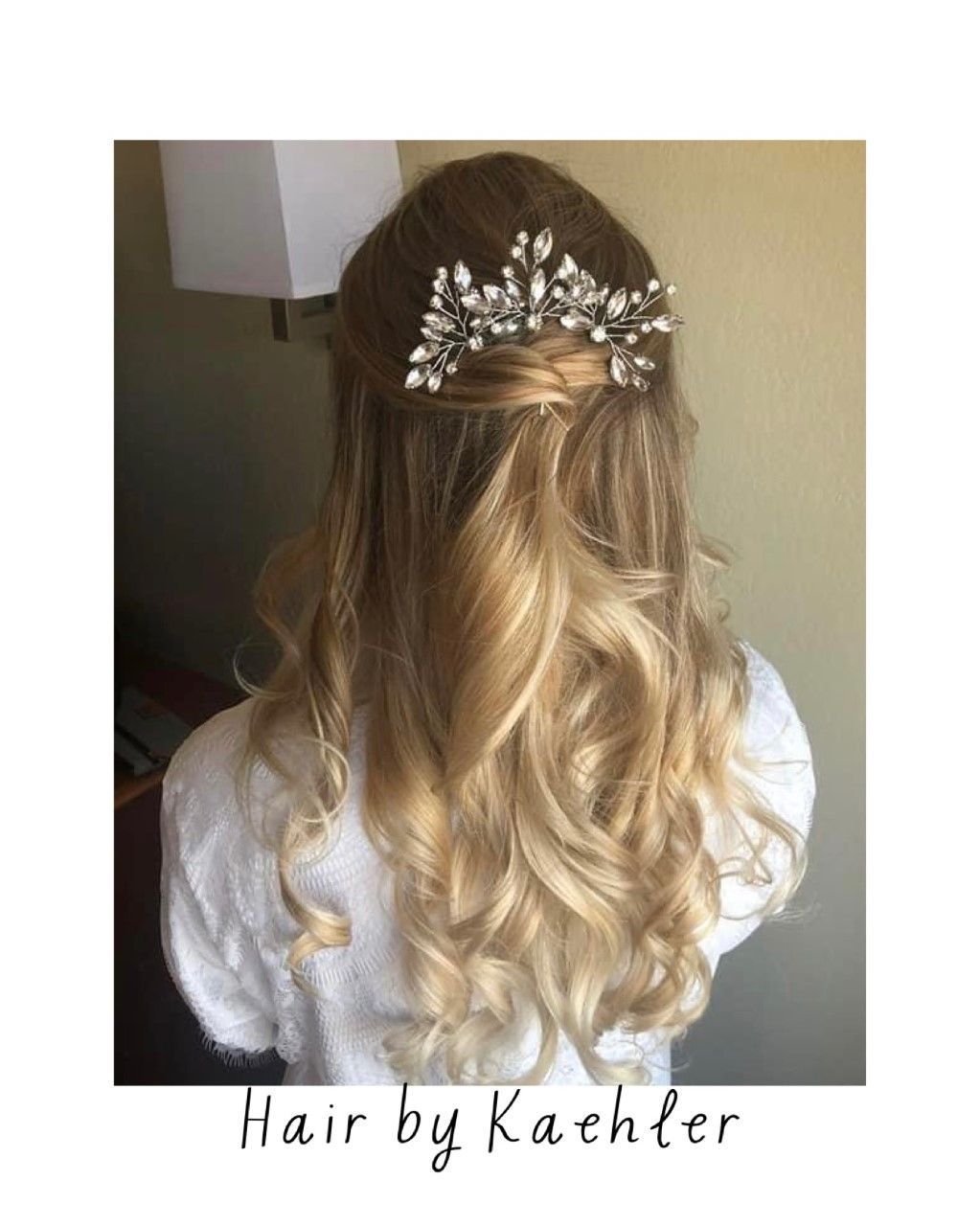 Long wavy blonde hair with a jeweled floral hair accessory on the back of the head