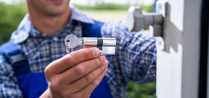 A man is holding a key in front of a door.