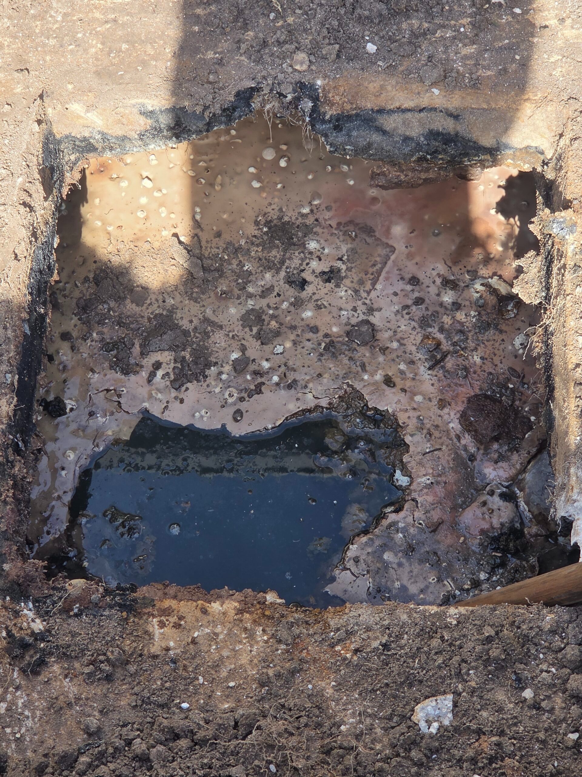 Charred wall with a dark rectangular opening and soot-stained rubble at the base