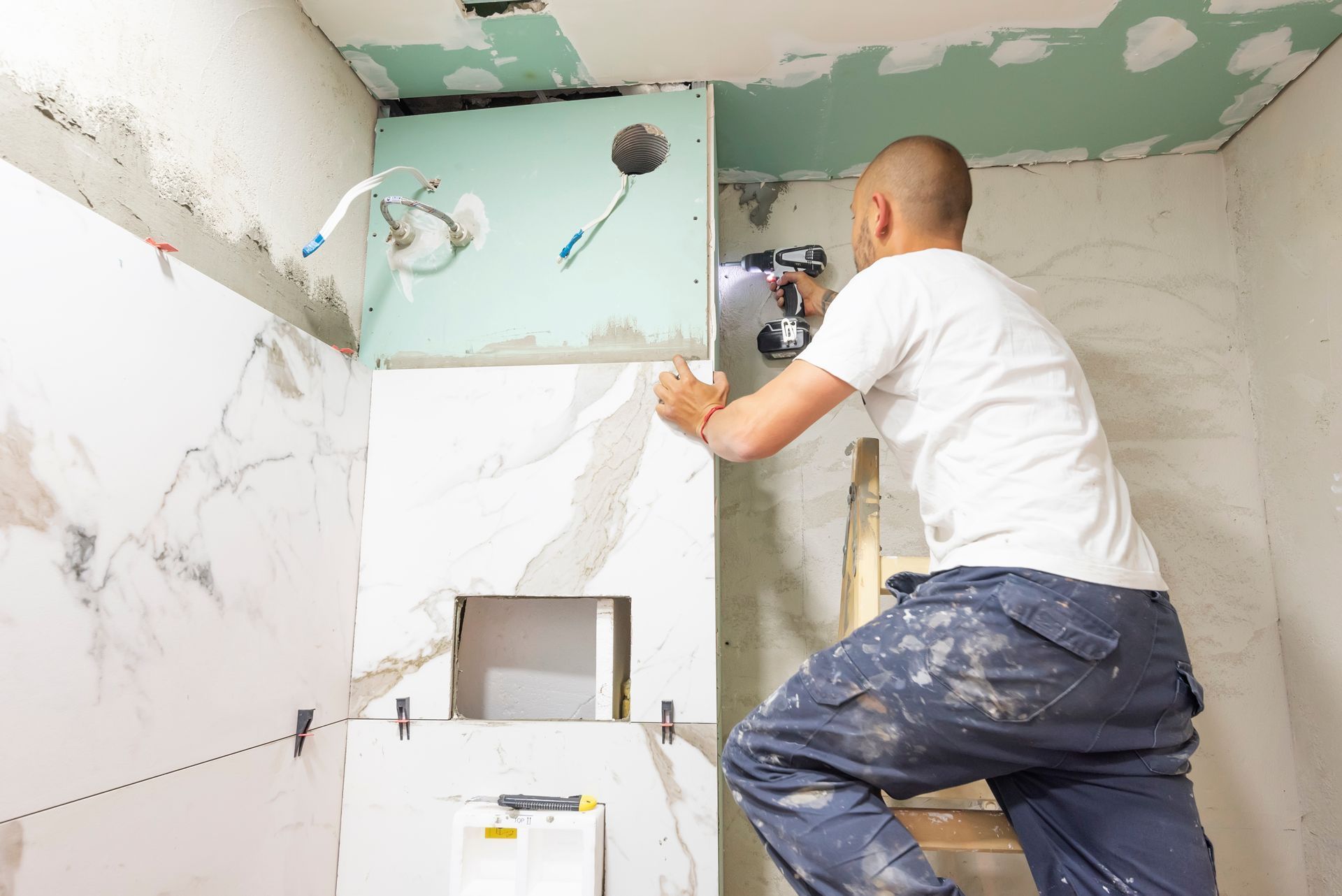 A man is working on a bathroom remodel.
