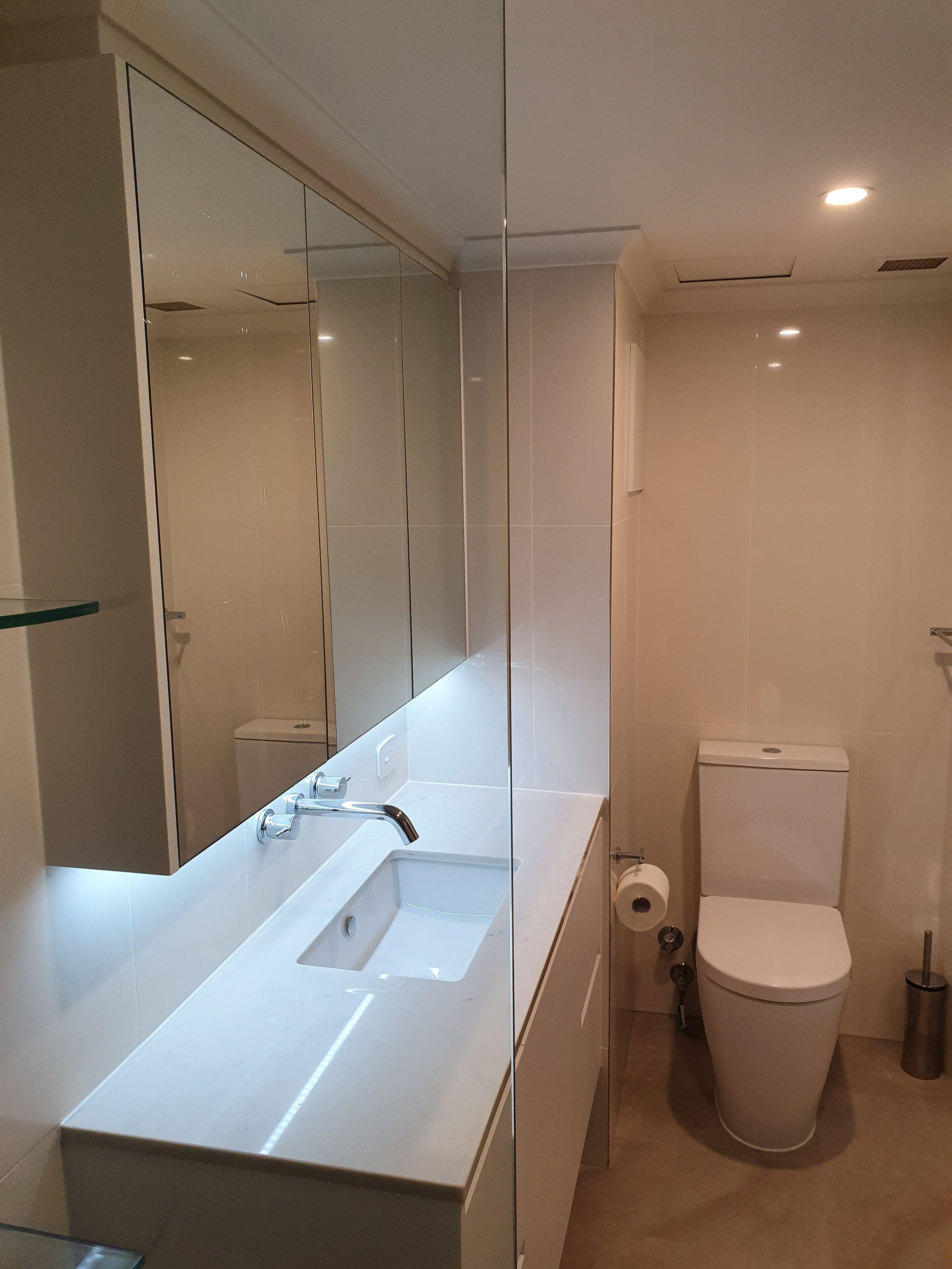 A Bathroom With a Sink, Toilet and Mirror  — Scott Graham Building Services In Bilambil Heights, NSW 