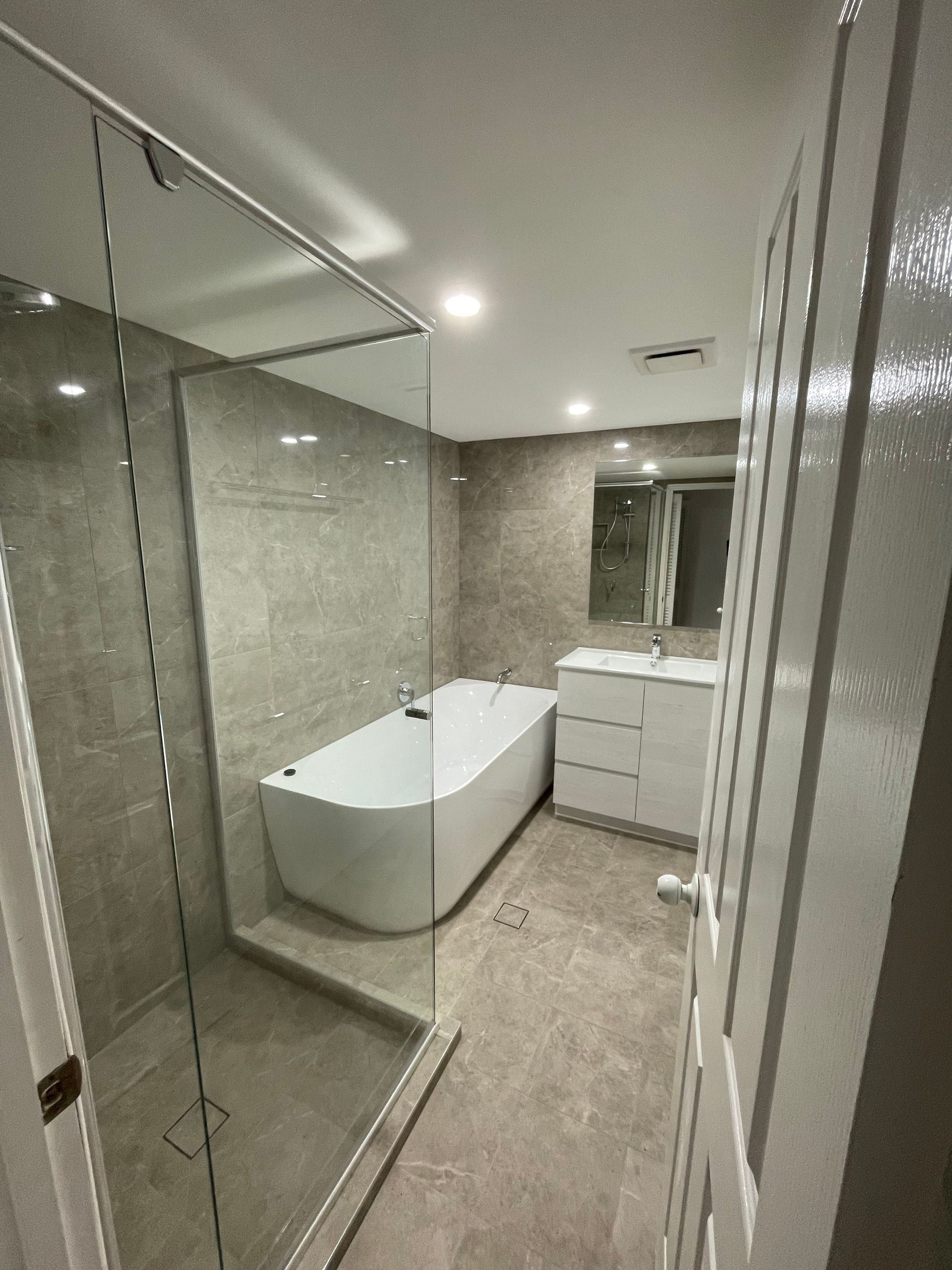 A Bathroom With a Bathtub and a Walk in Shower  — Scott Graham Building Services In Bilambil Heights, NSW 
