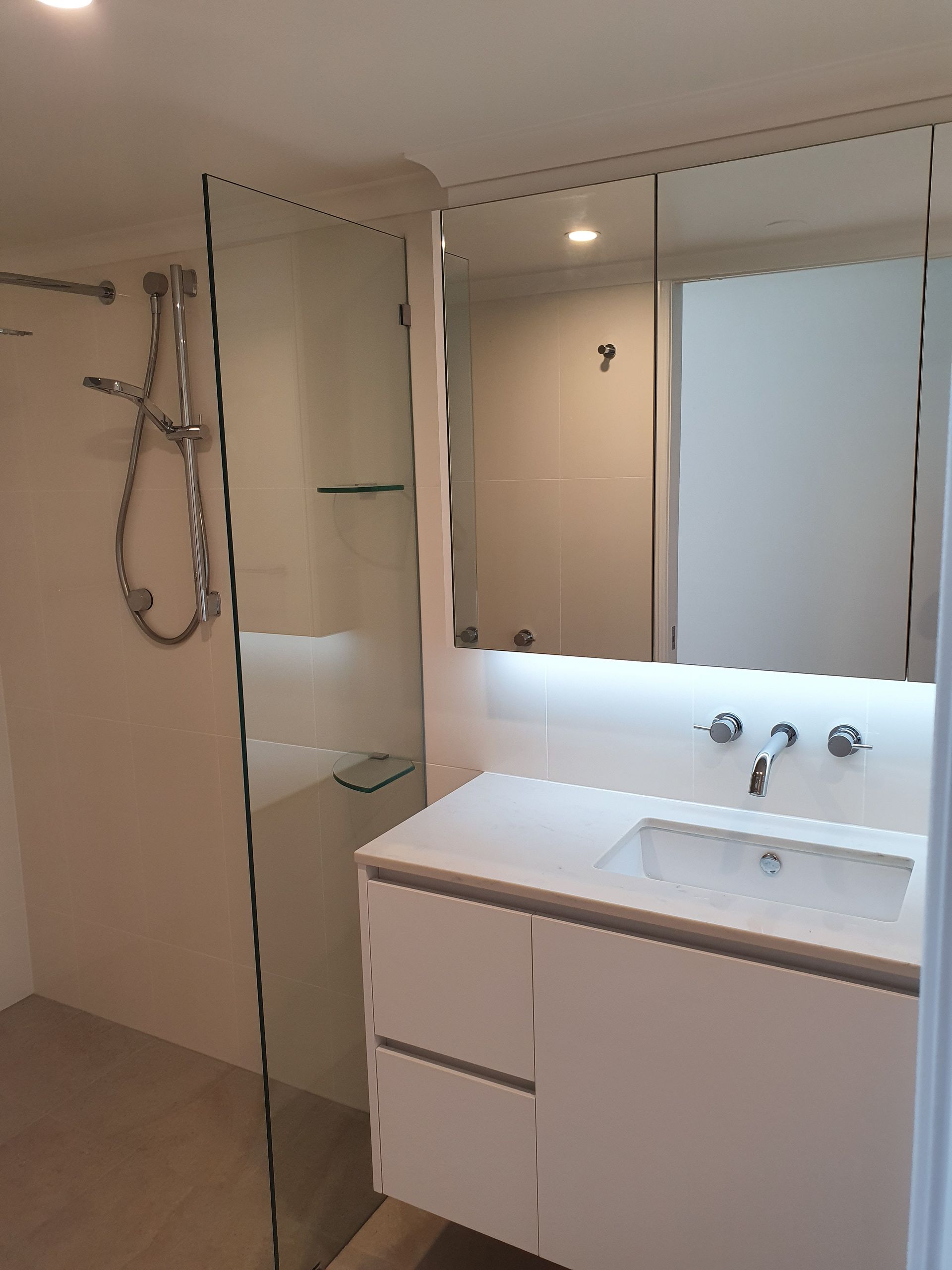 A Bathroom With a Sink, Mirror and Shower  — Scott Graham Building Services In Bilambil Heights, NSW 