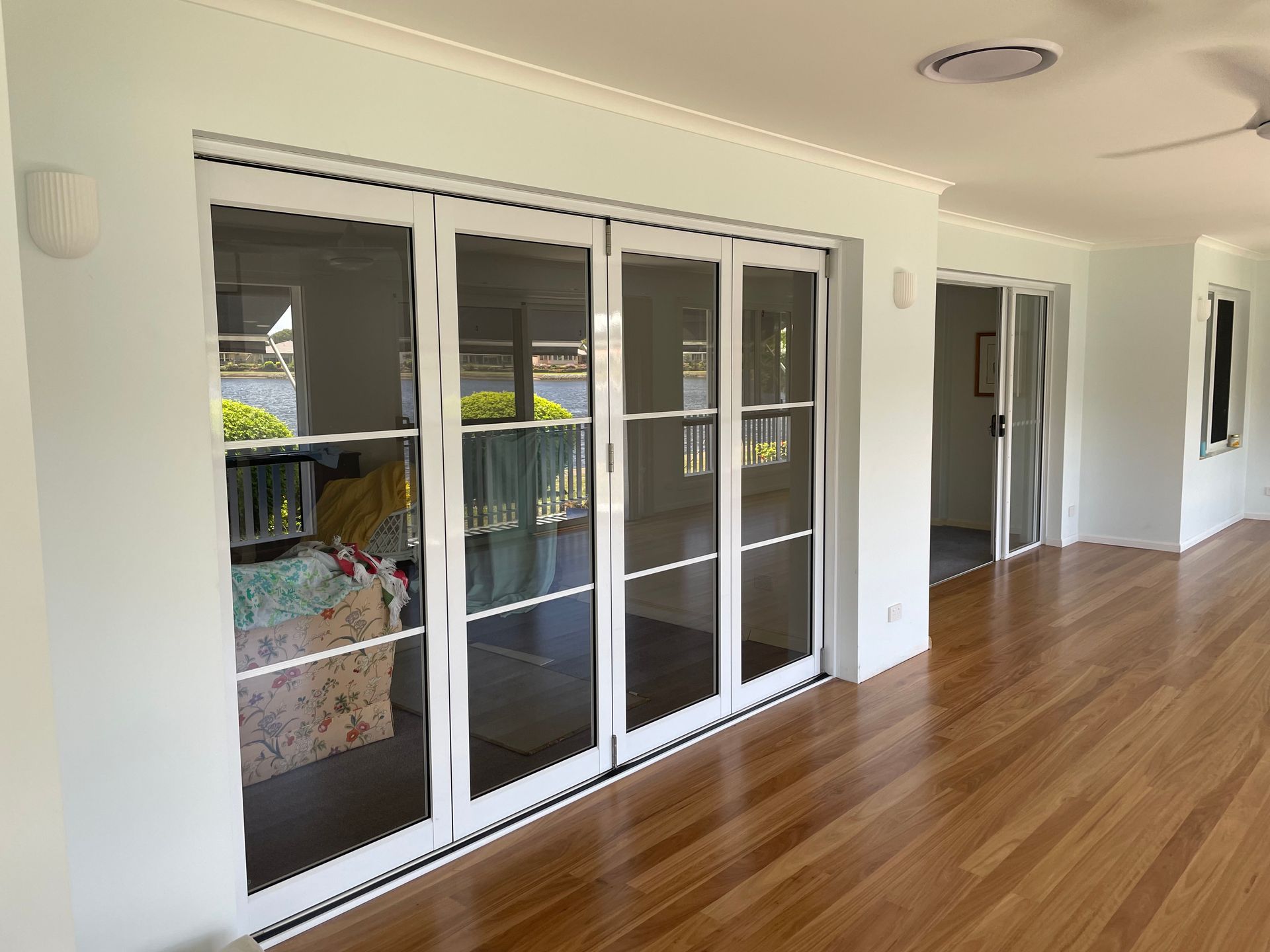 A Living Room With Hardwood Floors and Sliding Glass Doors — Scott Graham Building Services In Bilambil Heights, NSW
