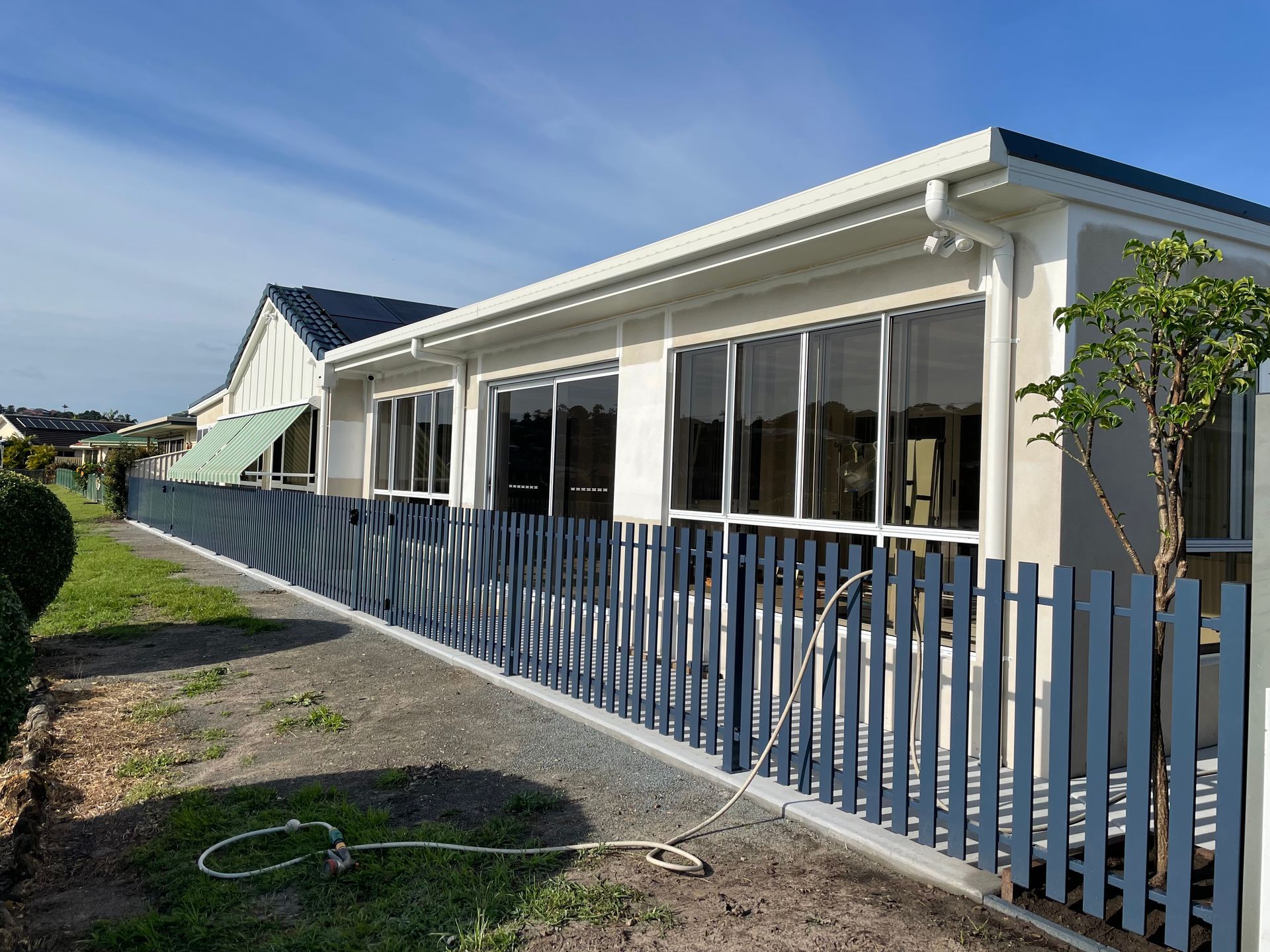 A House With A Green Garage Door And A Brick Driveway — Scott Graham Building Services In Bilambil Heights, NSW