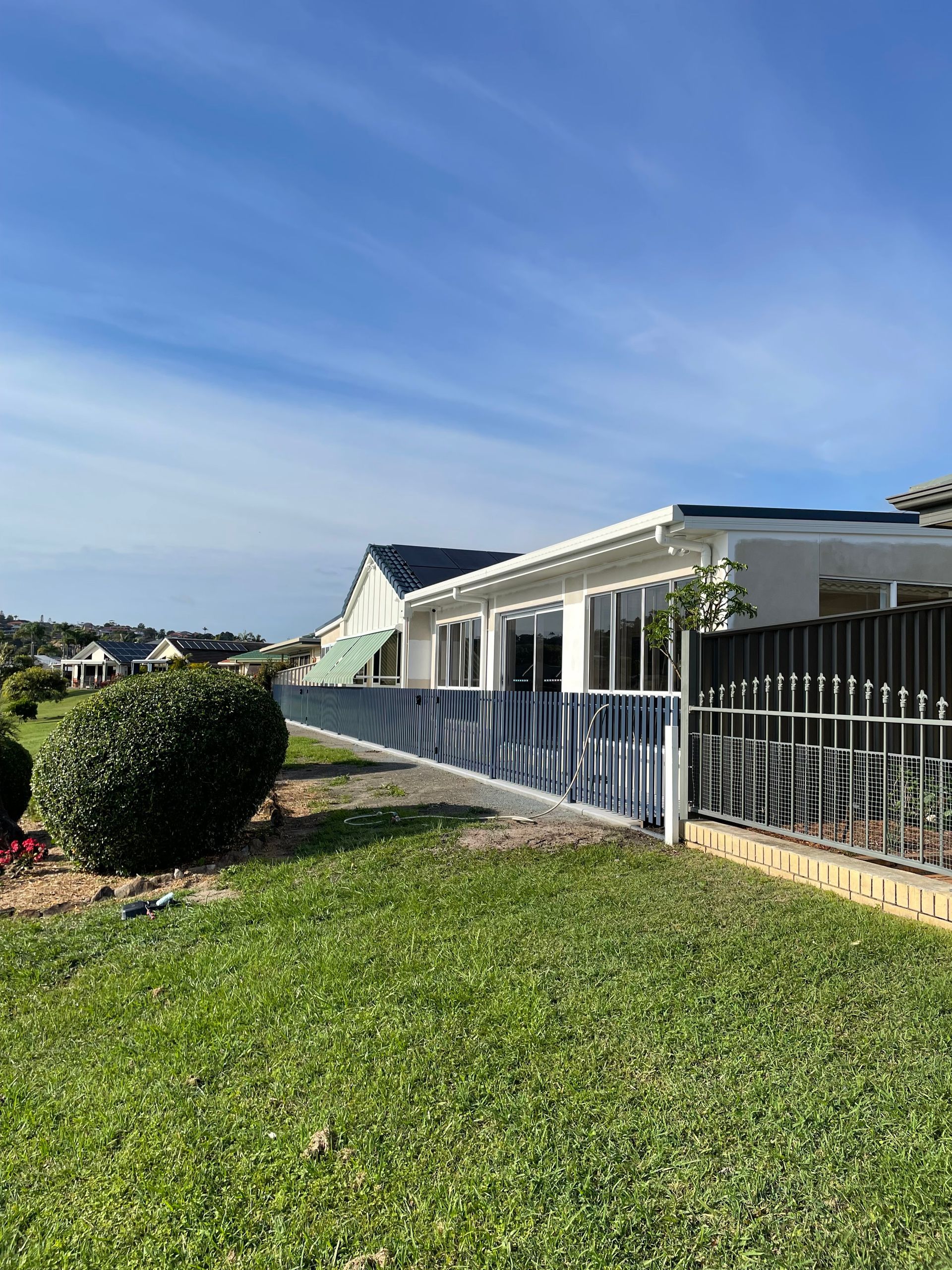 A Mobile Home With a Fence in Front of It in a Residential Area — Scott Graham Building Services In Bilambil Heights, NSW