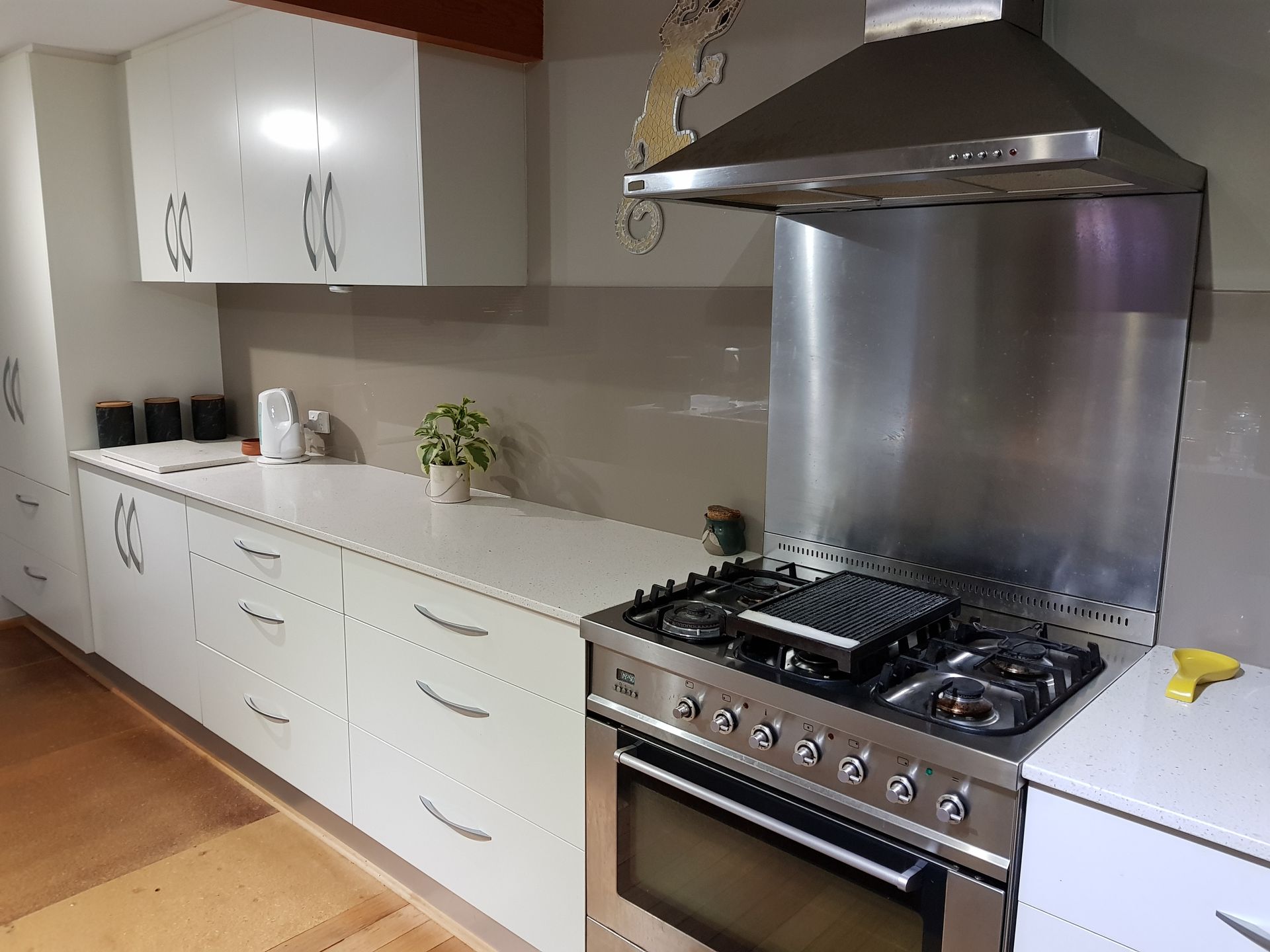 A Kitchen With White Cabinets And A Large Island — Scott Graham Building Services In Bilambil Heights, NSW 