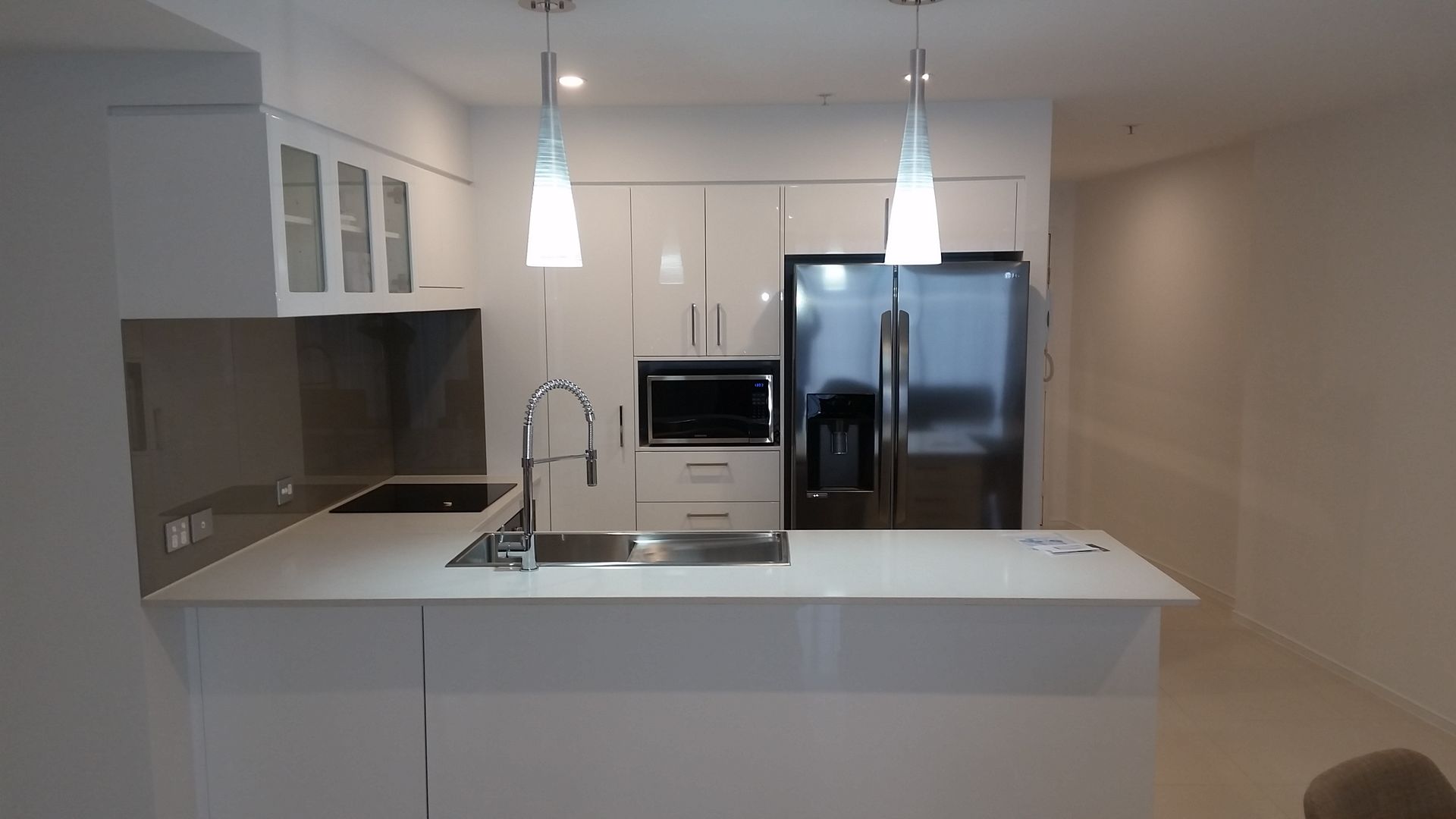 A Kitchen With White Cabinets , Stainless Steel Appliances, a Sink and a Refrigerator  — Scott Graham Building Services In Bilambil Heights, NSW 