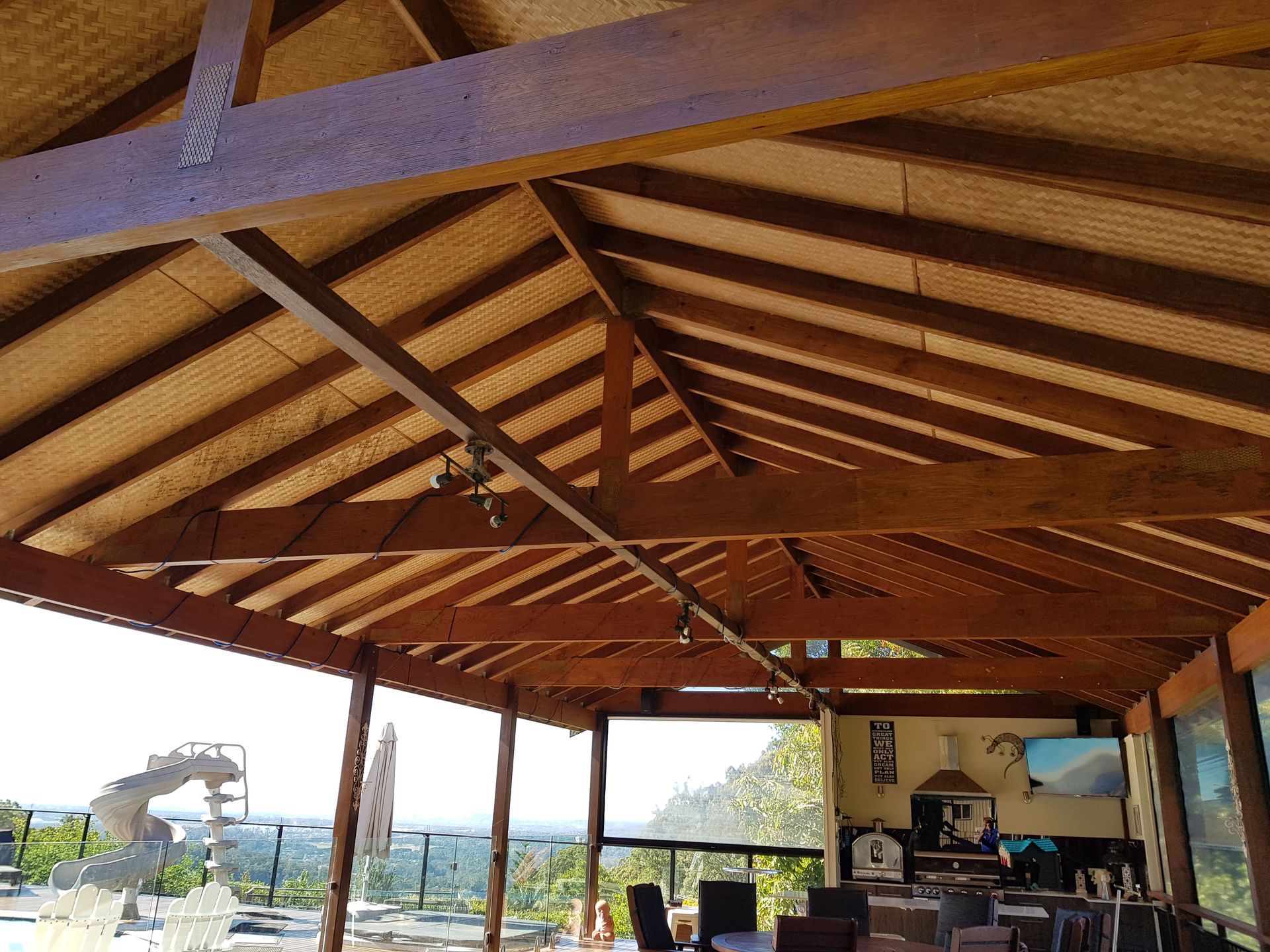 The Inside of a Wooden Building With a Thatched Roof  — Scott Graham Building Services In Bilambil Heights, NSW 
