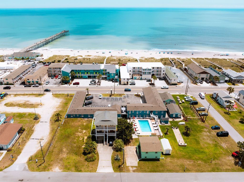 An aerial view of Seabirds Motel at Kure Beach, showing the surrounding neighborhood and proximity to the ocean. The image showcases the motel's prime location for a pet-friendly stay in North Carolina.