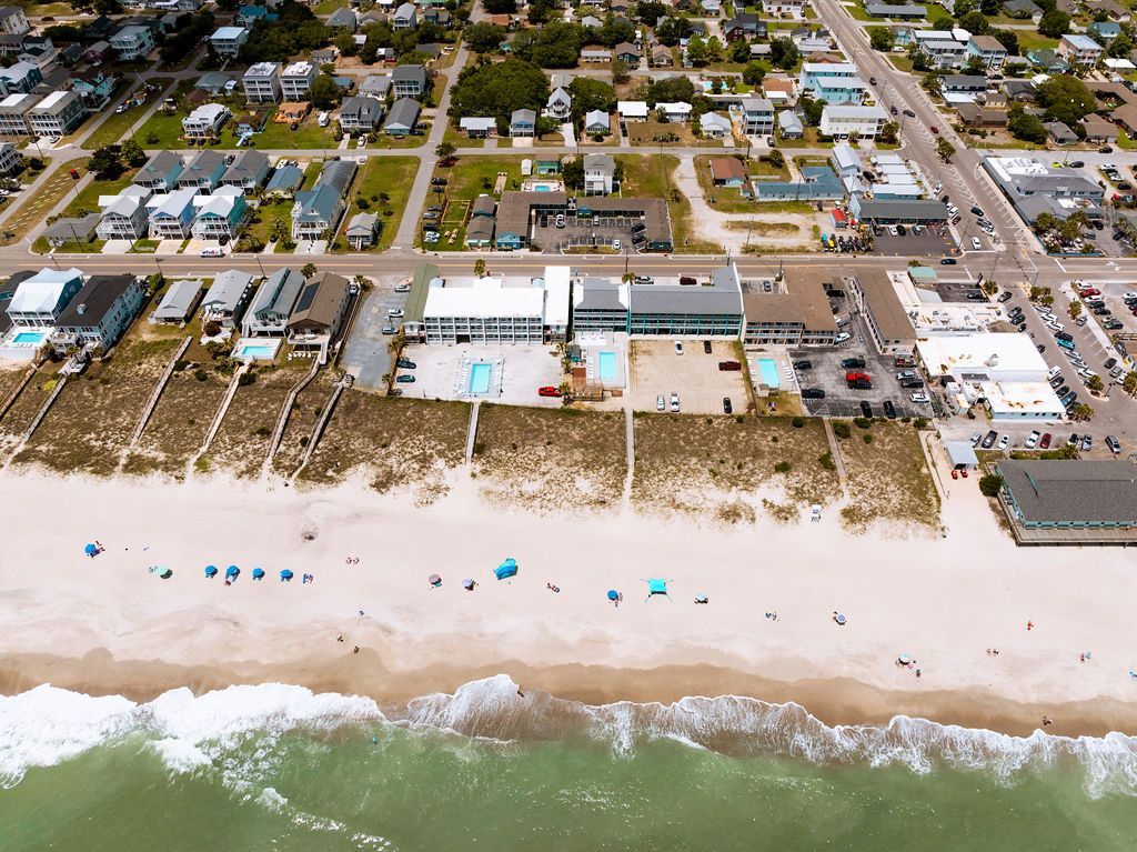  A wide aerial view of the coastline near Seabirds Motel at Kure Beach, illustrating the motel's close access to the beach and ideal setting for a pet-friendly lodging experience in North Carolina.